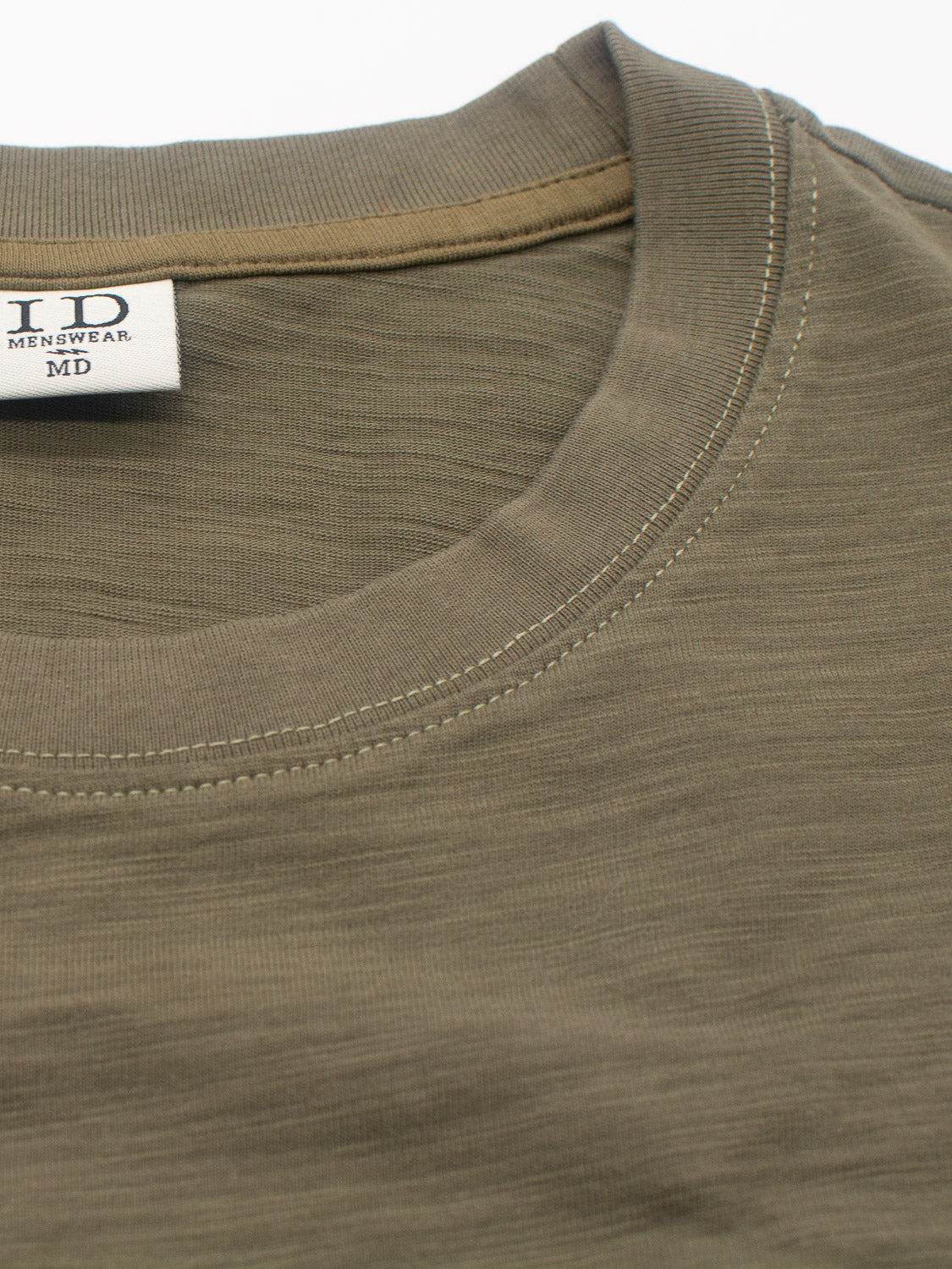 Close-up of an olive green slub yarn t-shirt neckline with visible stitching. The label inside shows ID Menswear and size MD. The Big Flip Slub Yarn Cotton Tee, made of 100% cotton, offers a subtle texture and relaxed, boxy fit for everyday comfort.