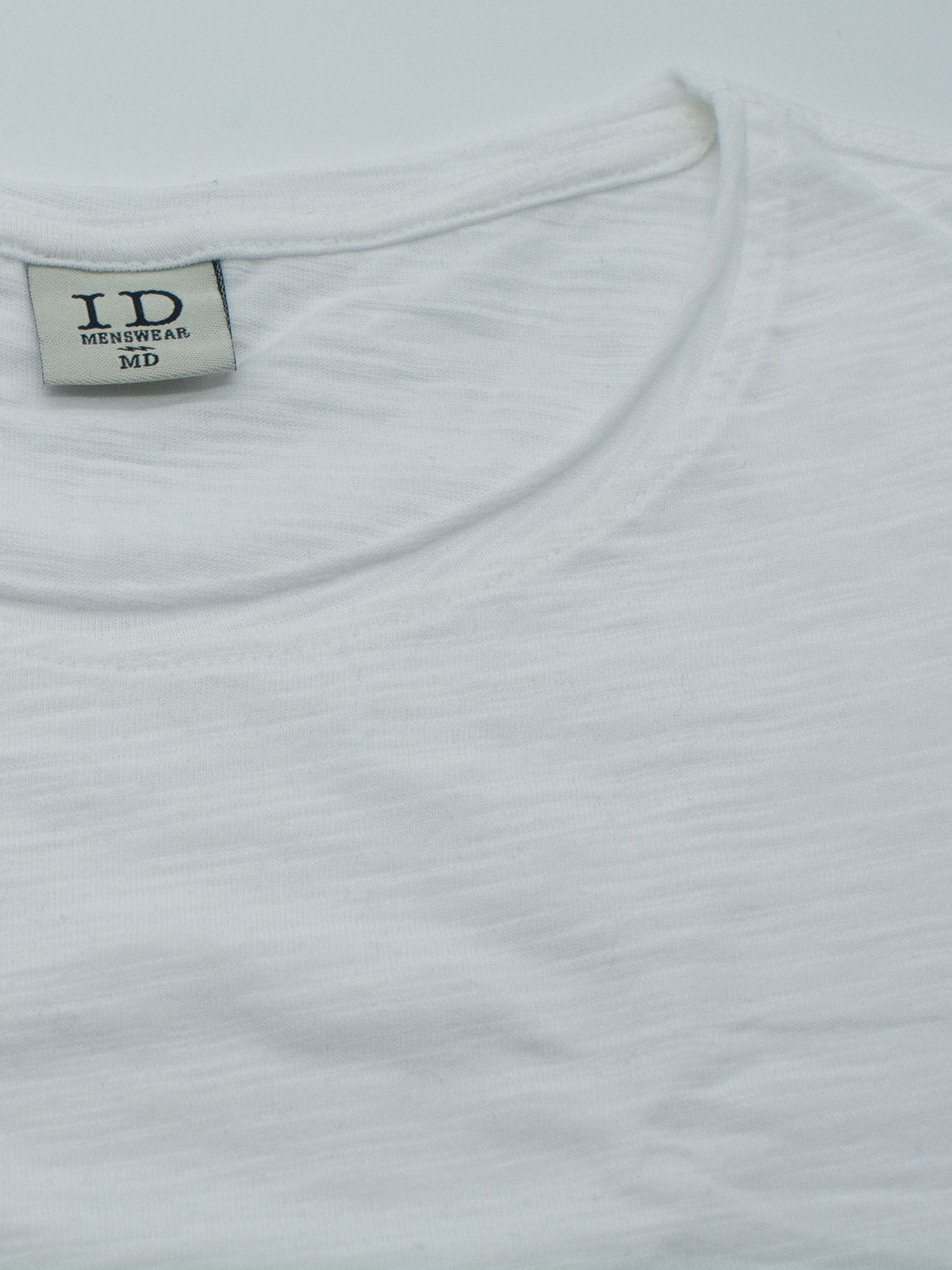 Close-up of the Da Nang Rolled Neck Slub Tee by ID Menswear, a white slub cotton crew-neck with an inner collar label reading ID MENSWEAR MD. The image highlights the textured fabric and rolled neck, focusing on the upper part of the shirt.