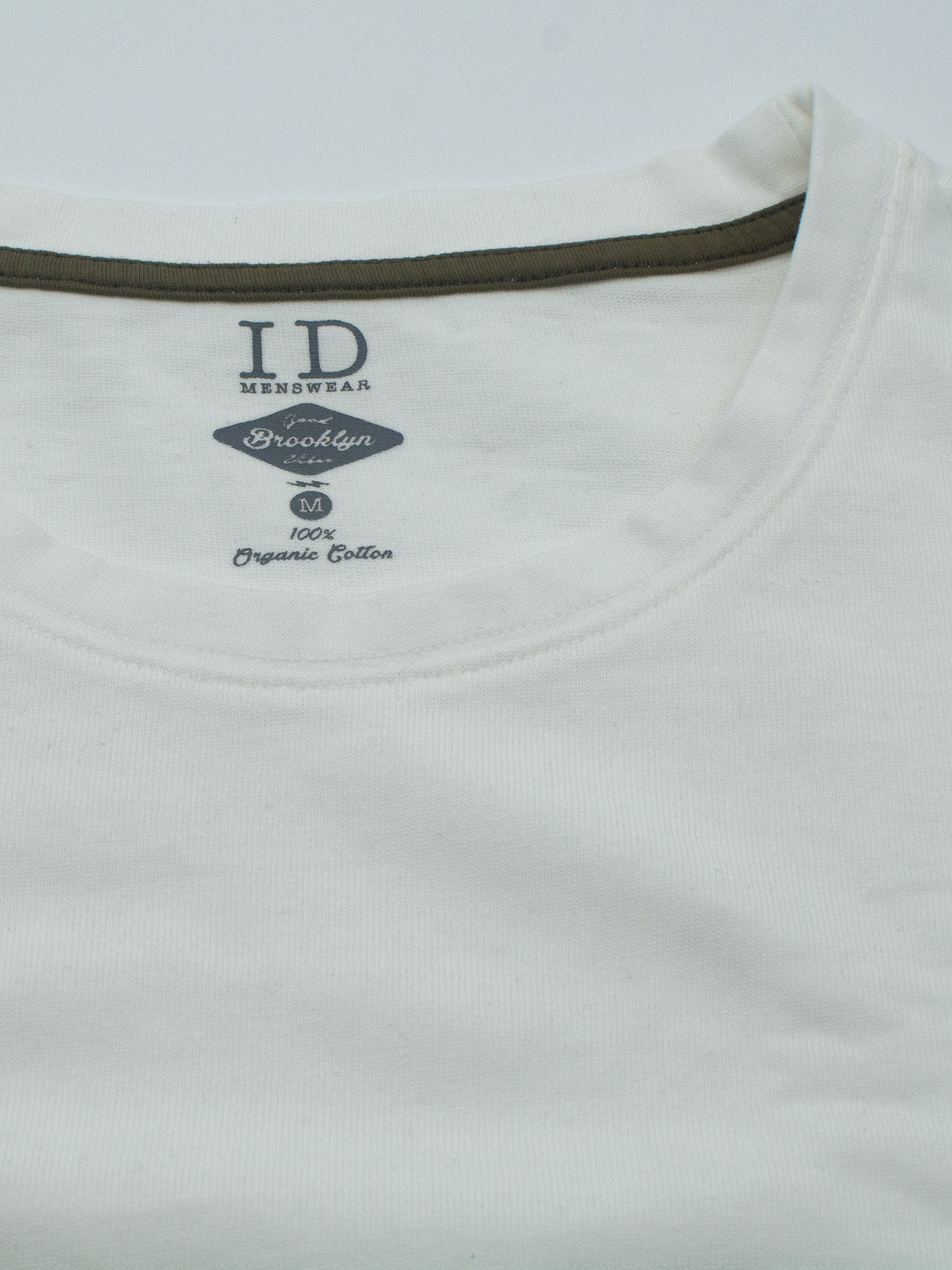 A close-up of the slim fit City Organic Cotton Tee by ID Menswear, showcasing a round neckline and dark green inner collar. Made from 100% organic cotton, size M—it’s ideal for the eco-conscious urbanite.