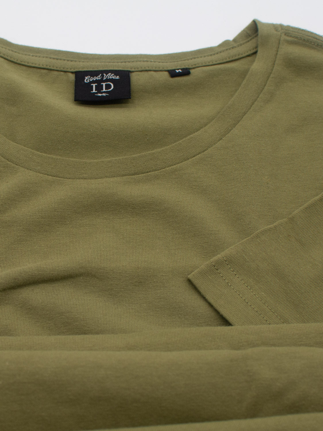 This olive green Form Crew Neck Tee by ID Menswear is neatly folded, features a classic crew neck, and comes in size L. Its fabric is smooth and soft, blending comfort with style.