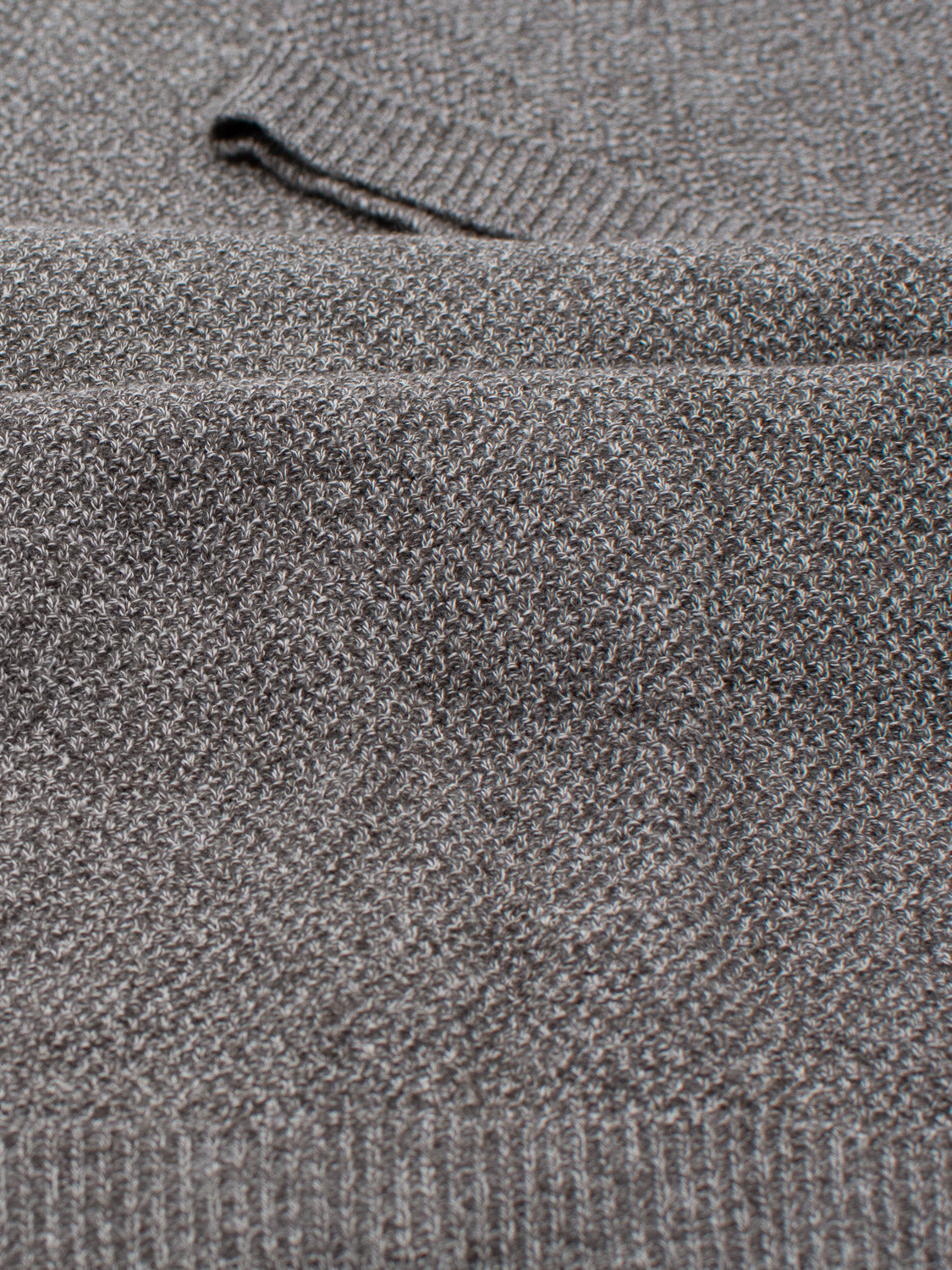 The Austin Knitted Cotton Polo by ID Menswear features a gray knit with a subtle herringbone pattern. Its detailed texture and ribbing near the edges combine style with a breathable fit, perfect for casual wear.