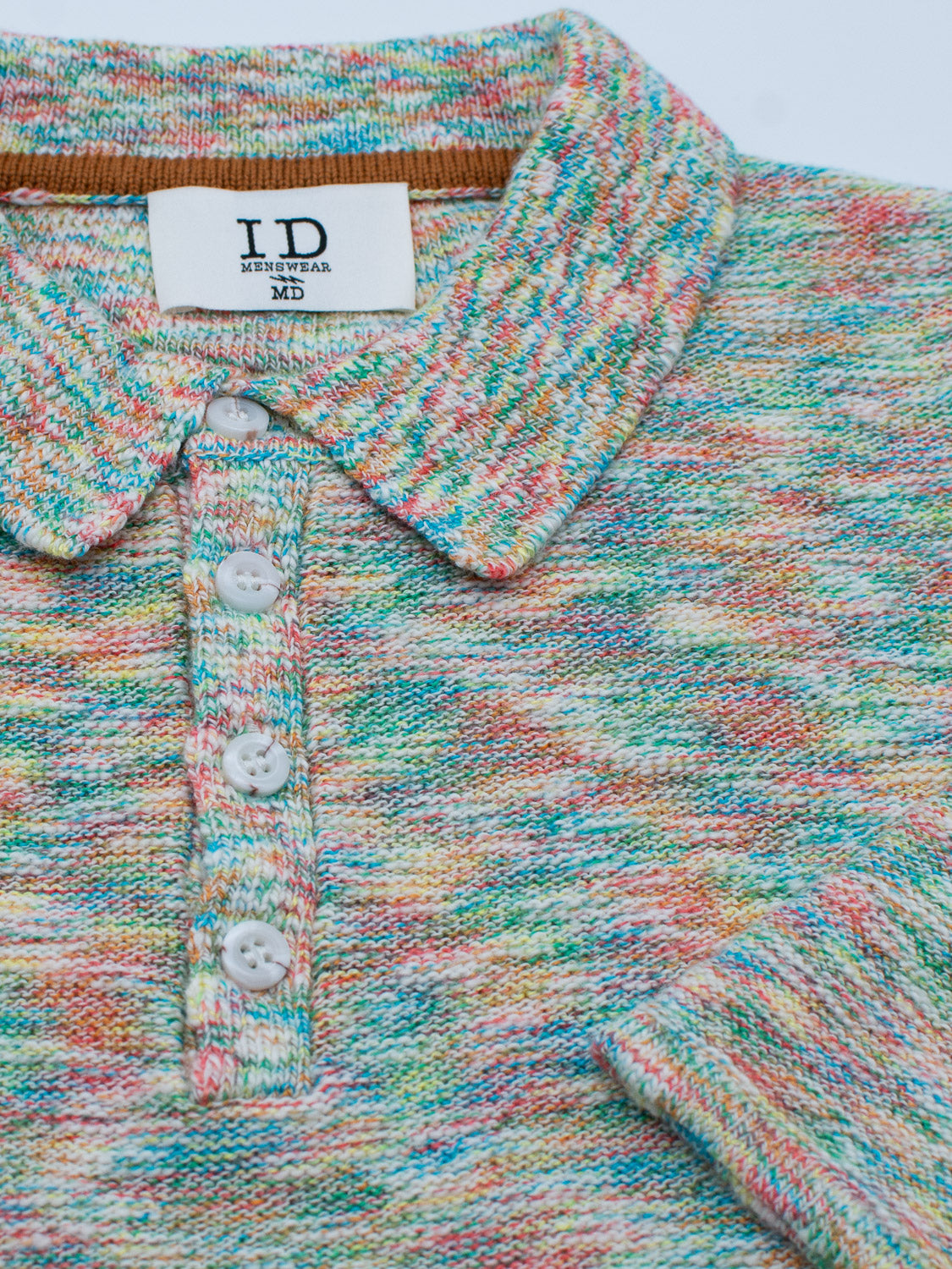 The Miami Reverse Knit Cotton Polo by ID Menswear boasts a speckled pattern in green, orange, red, and blue. It includes a collar, three white buttons, an ID knitwear MD label, and provides a breathable fit perfect for casual wear.