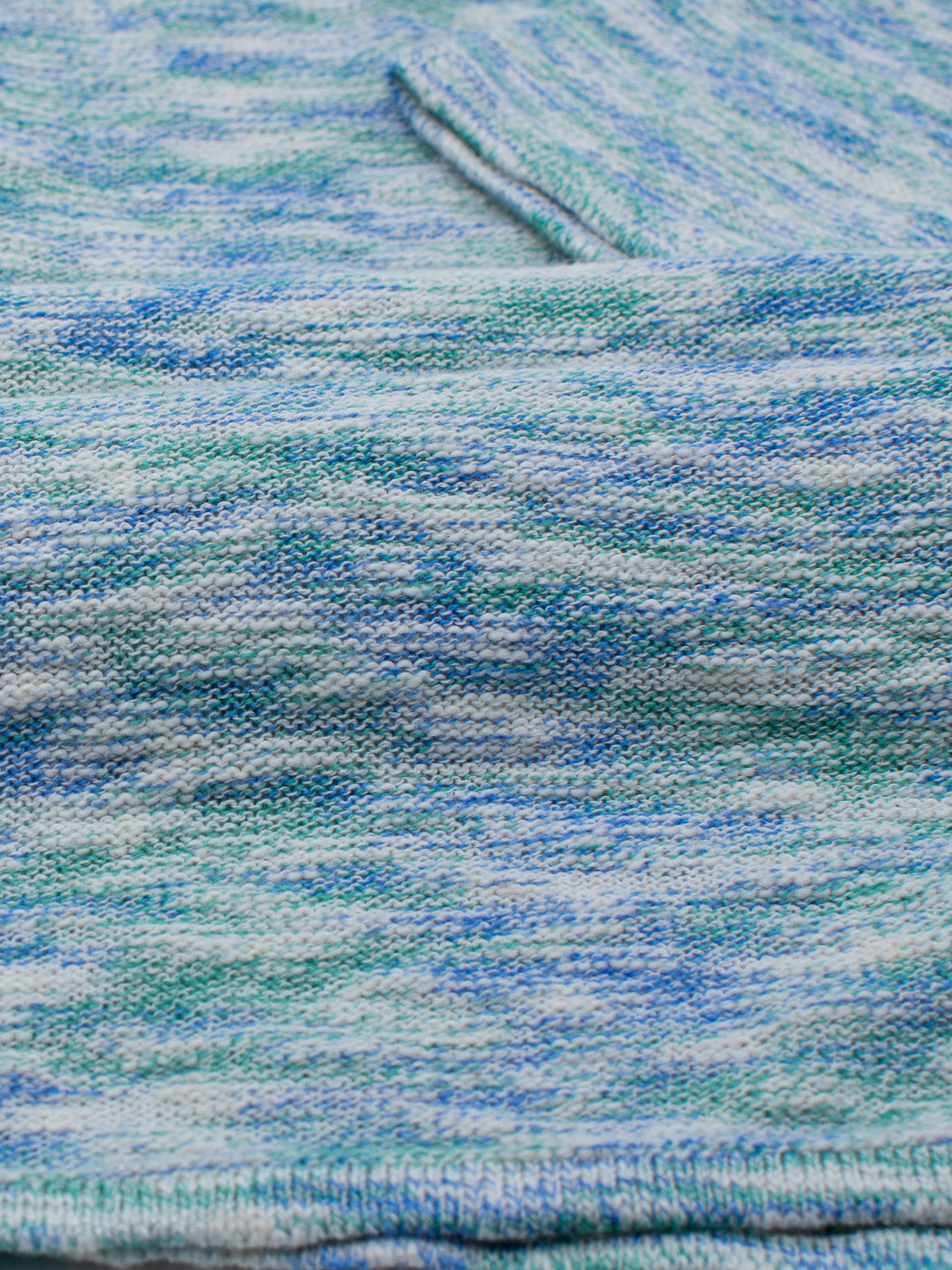 Close-up of ID Menswears Miami Reverse Knit Cotton Polo, featuring a mix of light blue, green, and white threads. The soft texture with a slightly marbled look is perfect for casual wear, while the visible hem ensures breathability.