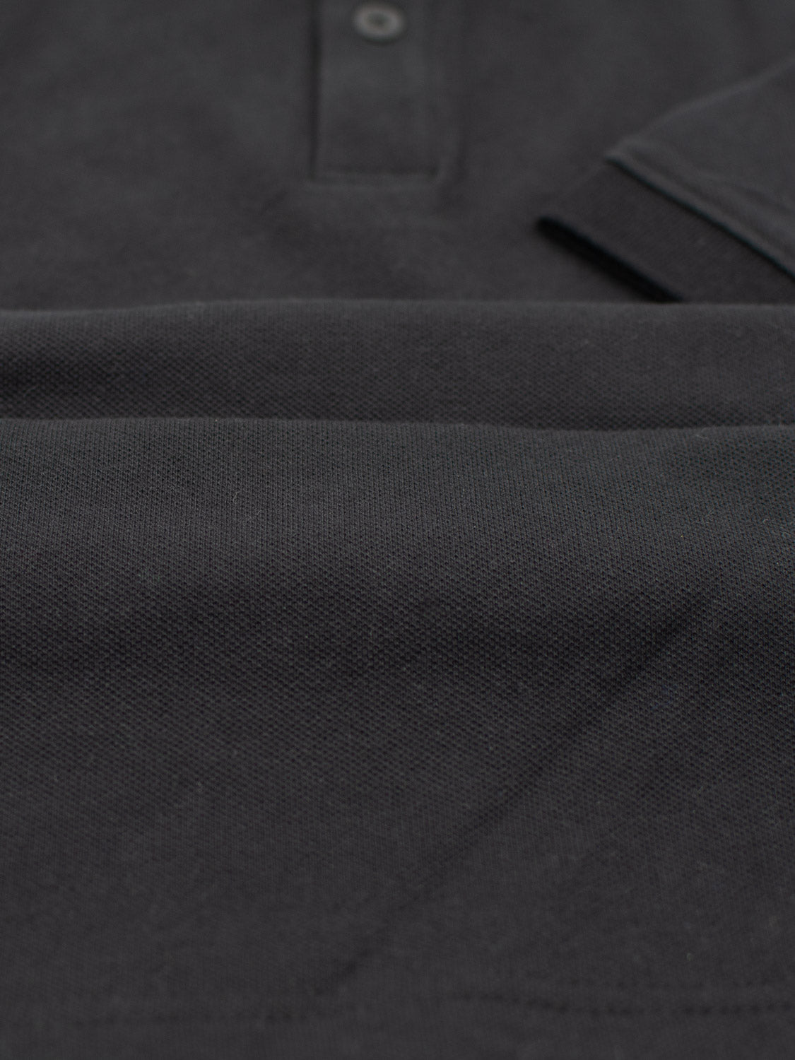 Close-up of a folded Ranger Classic Cotton Mesh Polo by ID Menswear, highlighting its lightweight cotton and textured fabric with a partial collar and buttons for classic styling.