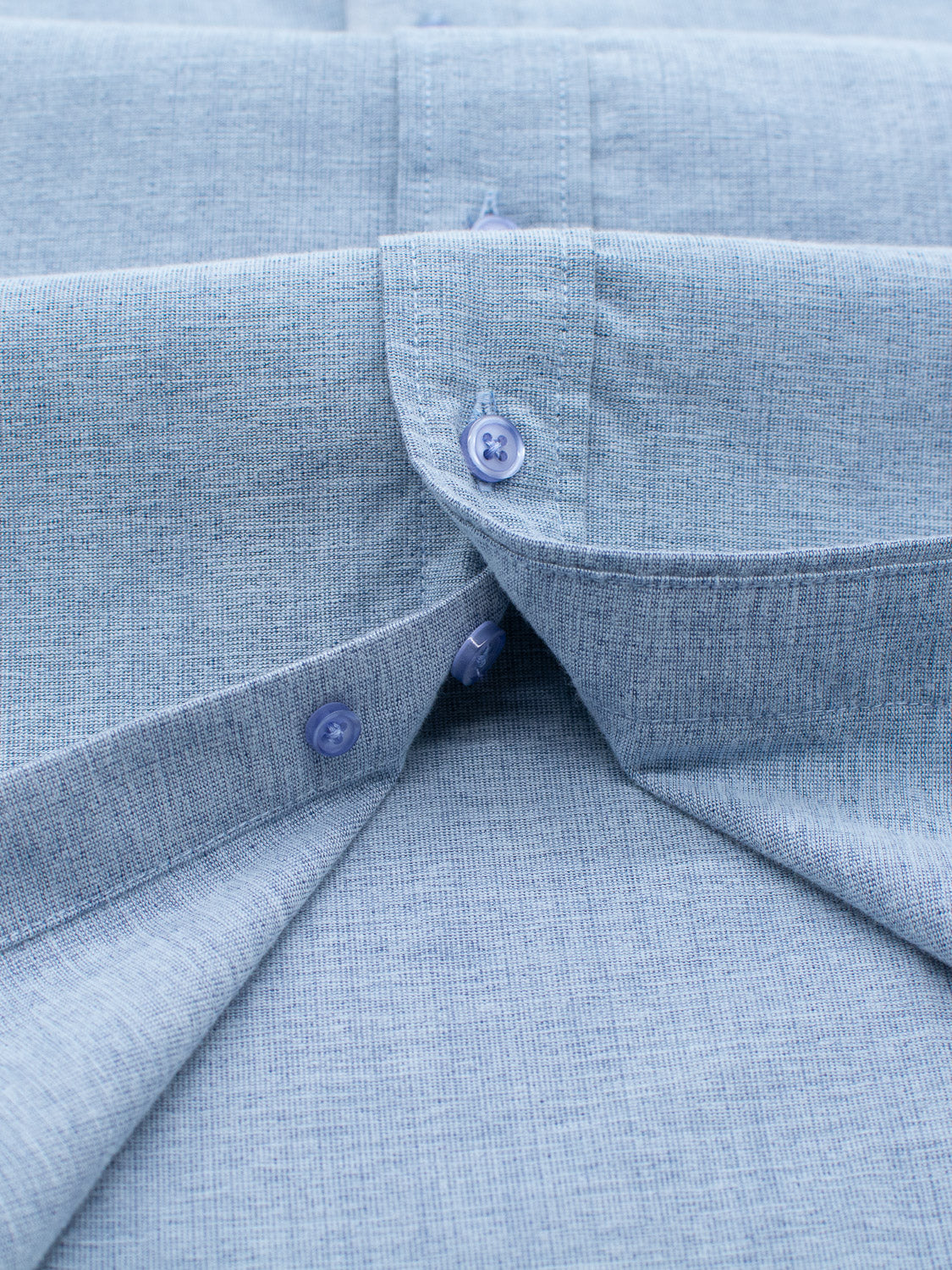 The Akira Cotton Button Down Shirt by ID Menswear features an open button-down collar with a subtle blue pattern. This regular-fit cotton shirt has two small dark blue buttons on each side, creating a neat and symmetrical appearance.