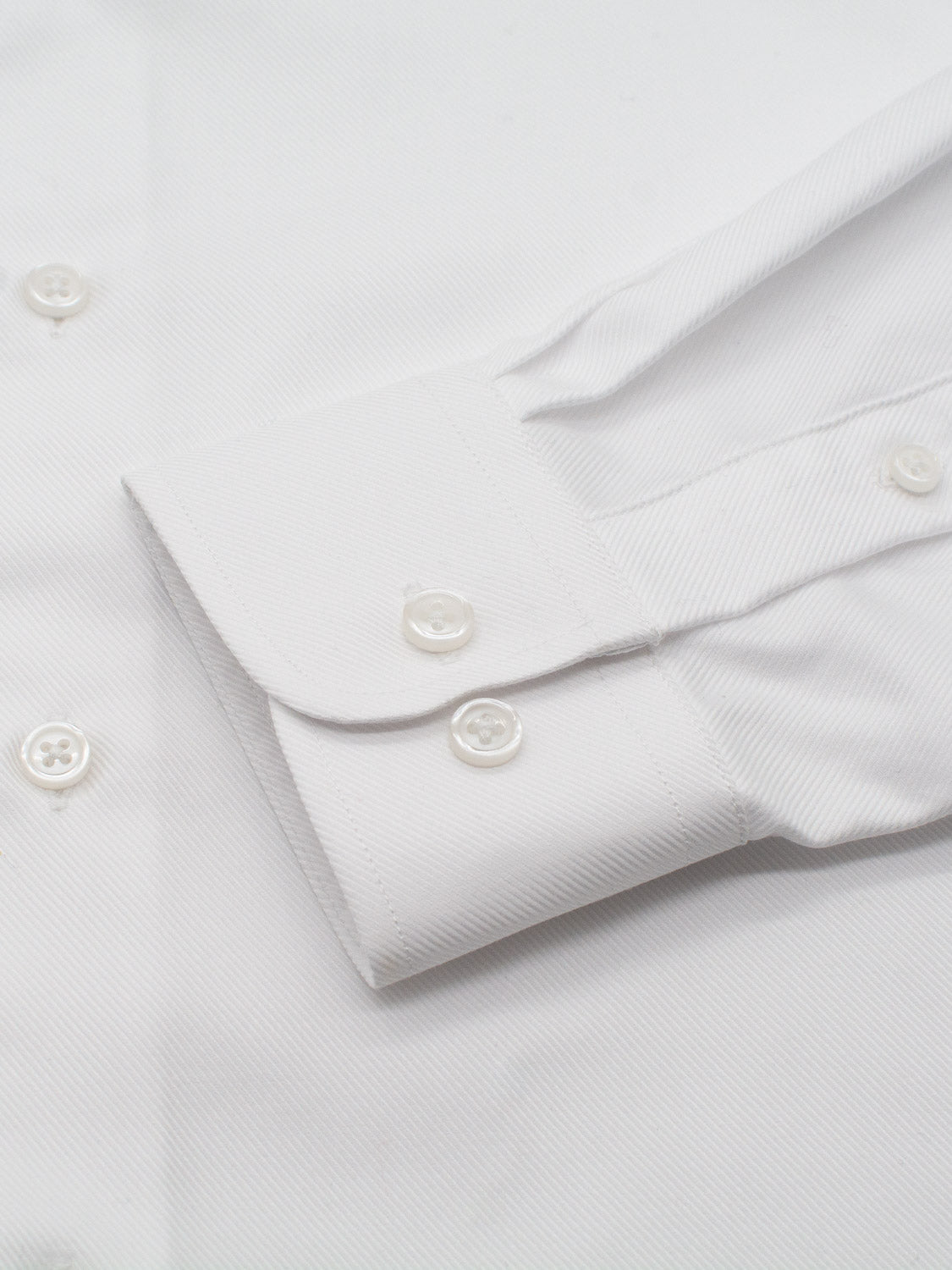 Close-up of the ID Menswear Cotton Dress Shirt in Slim Fit, featuring a white sleeve cuff with two buttons, part of the front with more white buttons, and a subtle diagonal weave pattern.
