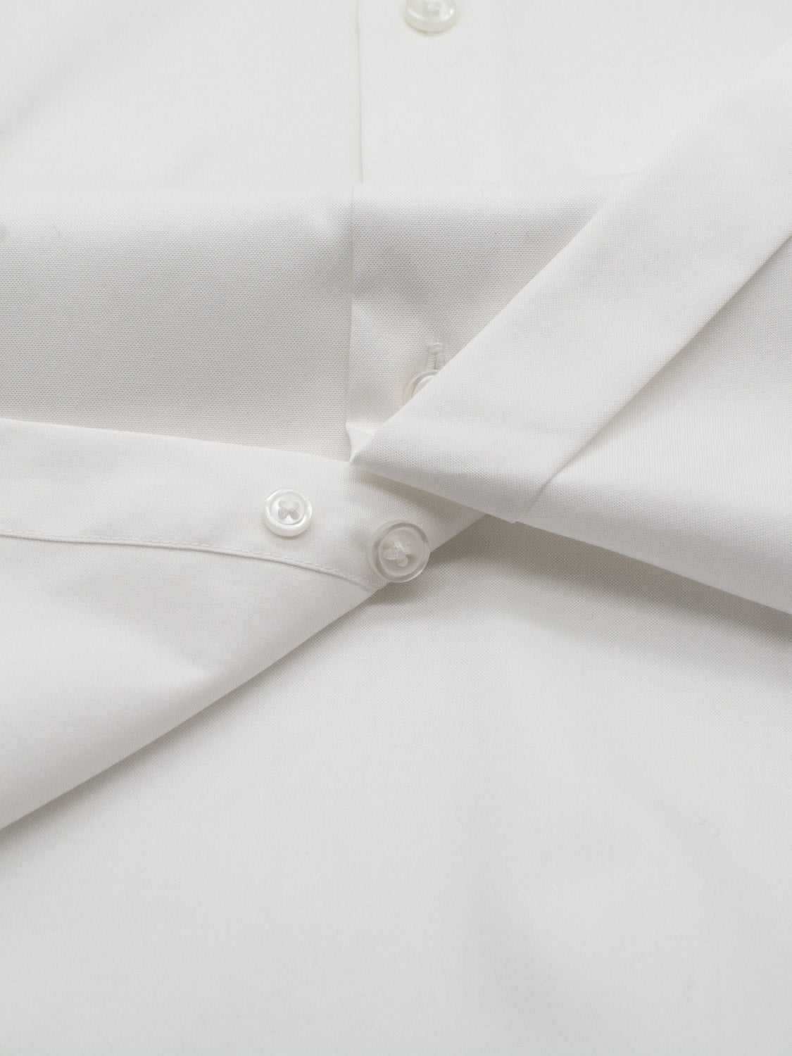 Close-up of the ID Cotton Dress Shirt by ID Menswear, showcasing its smooth fabric and well-defined buttonhole with buttons. The shirt is available in both slim and regular fits, offering a neat, crisp finish.