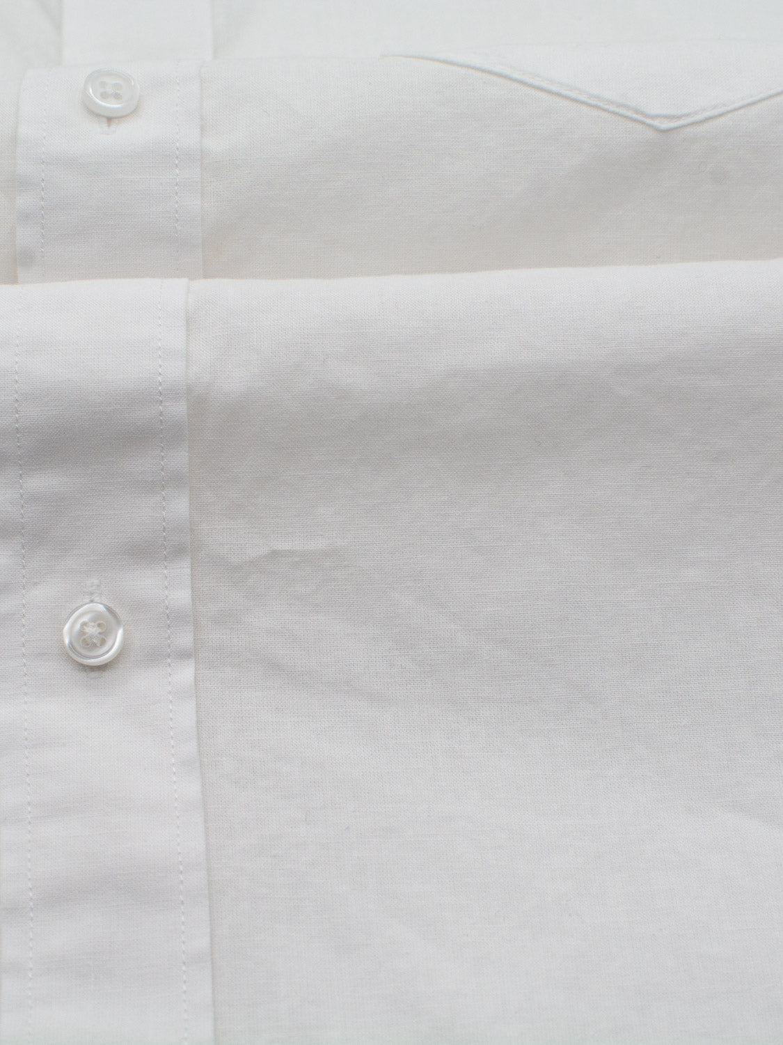 Close-up of an ID Menswear Goa Linen Cotton Long Sleeve Shirt showing its textured fabric and button details. The image highlights the shirts front with two white buttons, reflecting its lightweight, breathable nature. The shirt appears neatly pressed and clean.
