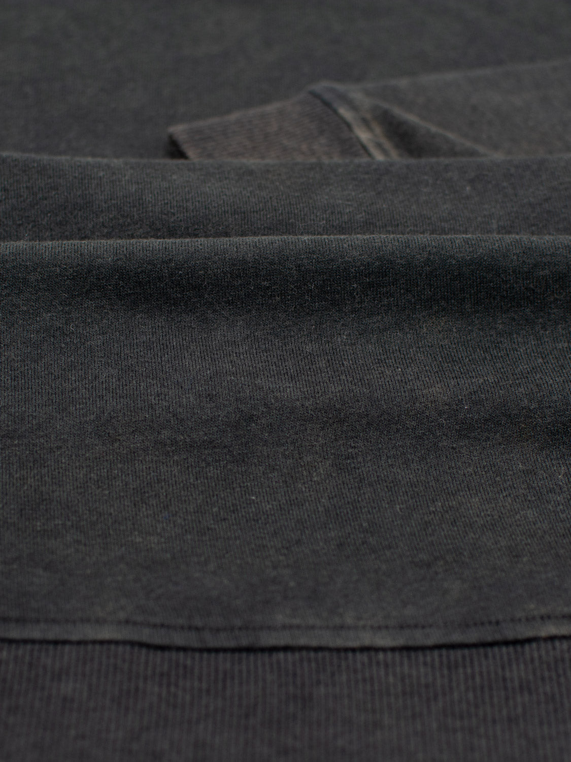 Close-up of a dark gray fabric from the Champ Bamboo Organic Cotton Sweatshirt by ID Menswear, showcasing its soft texture and subtle weave pattern crafted from bamboo organic cotton for an eco-friendly touch.