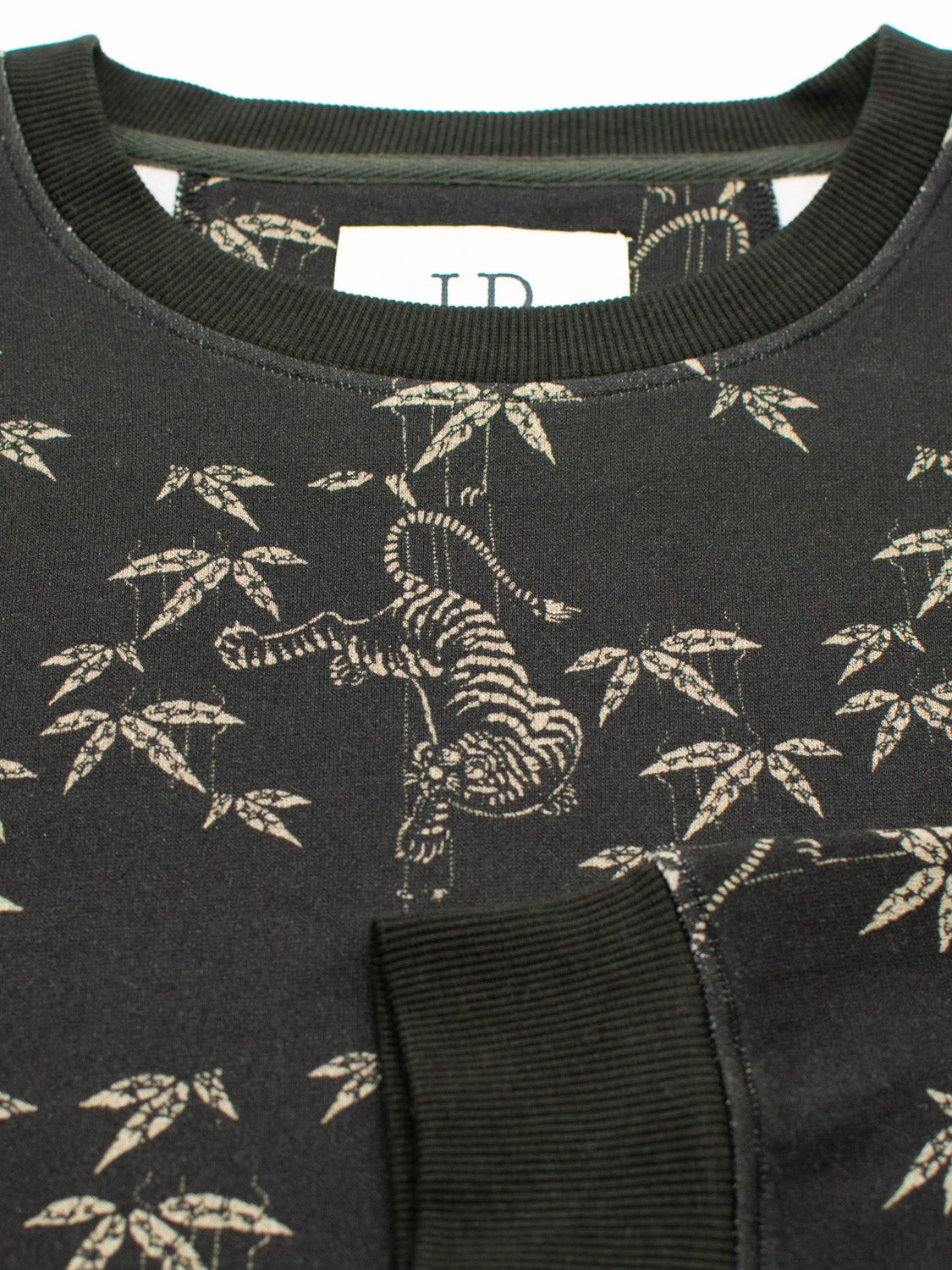 The ID Menswear Tiger Bamboo Printed Sweatshirt showcases a beige tiger pattern with bamboo leaves. Made from organic cotton, it has ribbed cuffs and a round neckline. A white tag is subtly visible at the collar, enhancing this bamboo fleece designs simplicity.