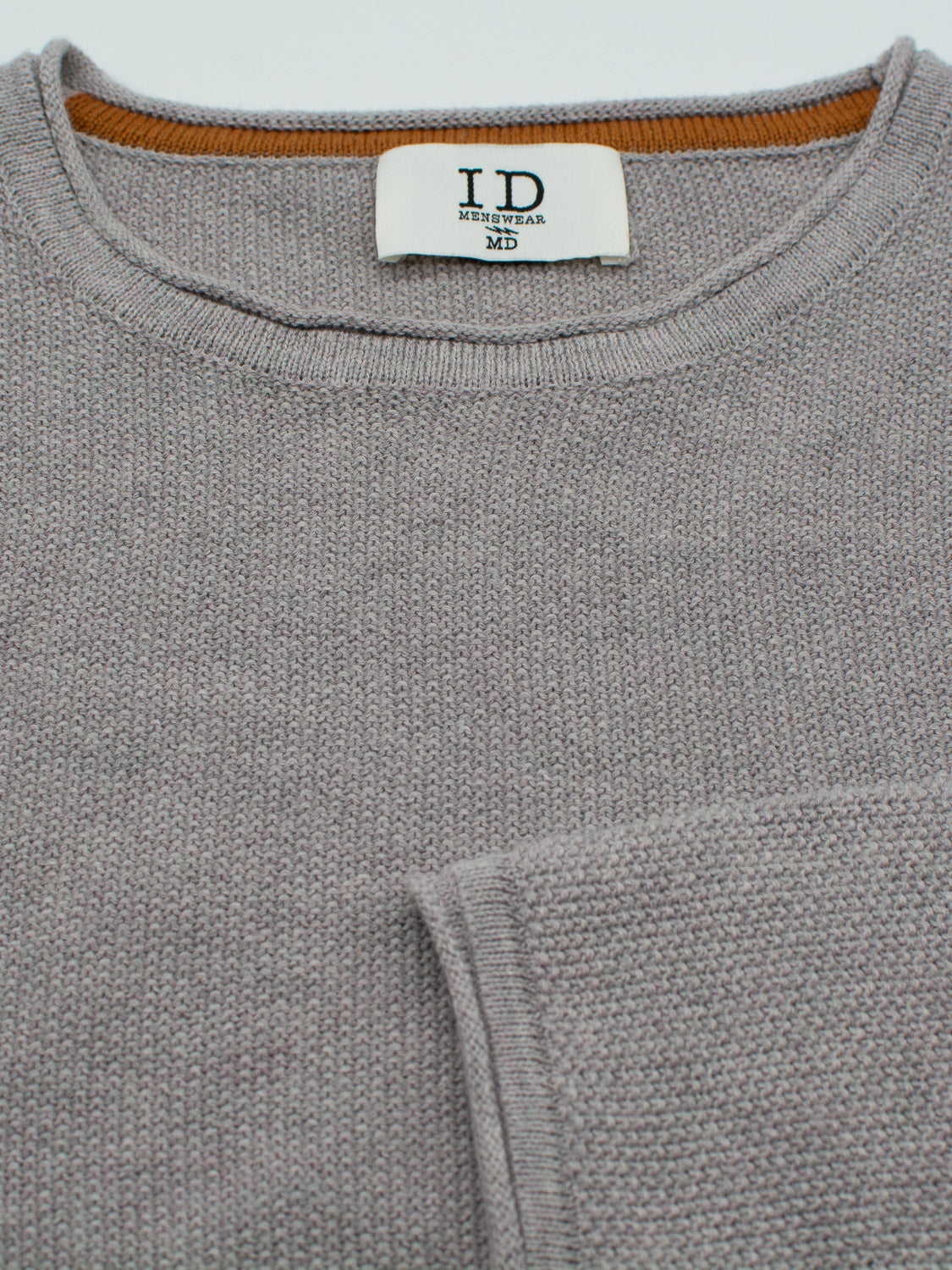 Close-up of the grey Madrid Rolled Neck Sweater Tee by ID Menswear, showcasing a mini popcorn knit and a visible label reading ID Menswear MD inside the soft rolled neck. A matching pocket is partially visible on this lightweight sweater.