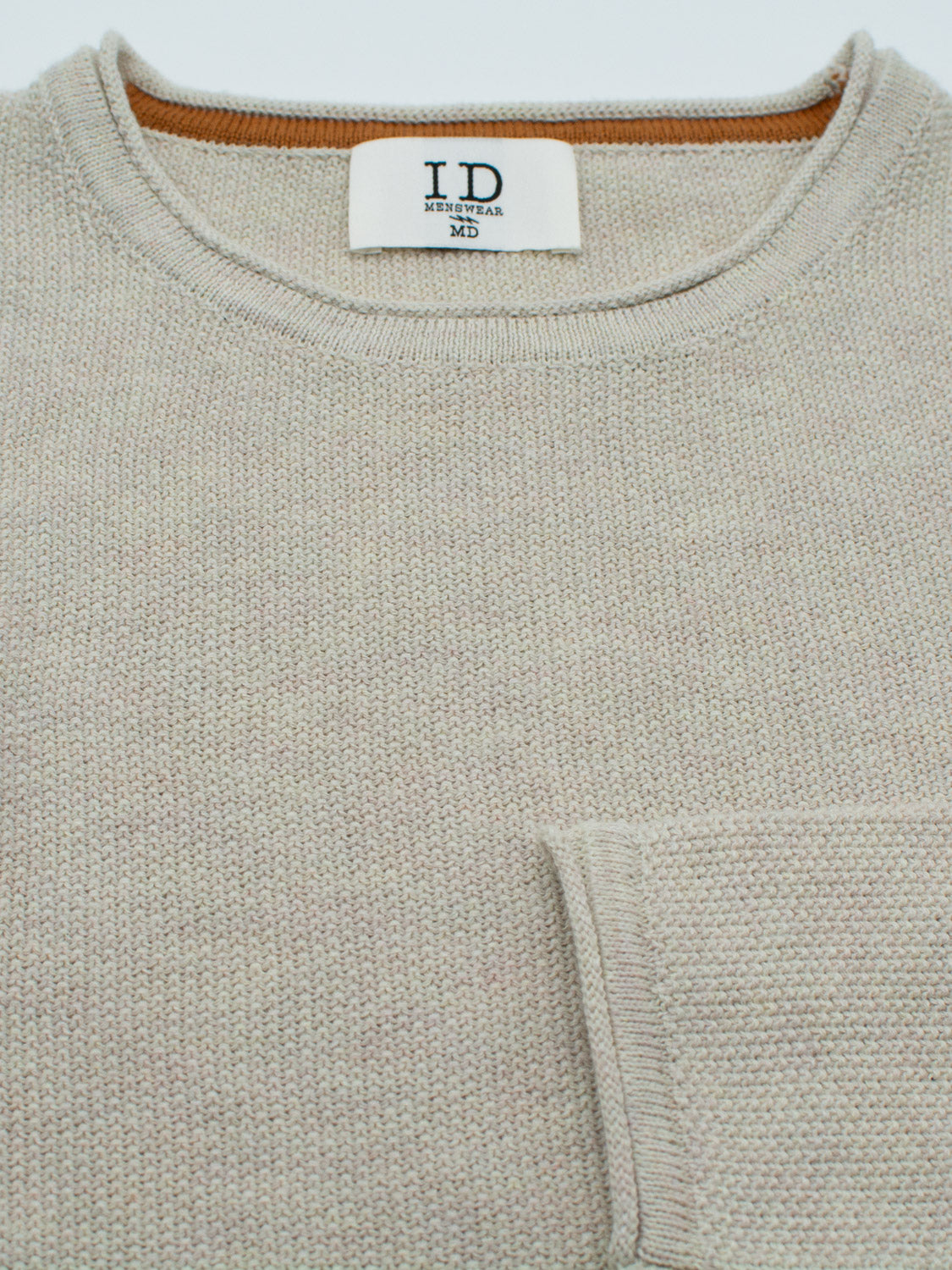 The Madrid Rolled Neck Sweater Tee by ID Menswear is a beige, lightweight piece with a soft rolled neck and mini popcorn knit texture. It features a left-side pocket and ID Menswear MD label, exuding casual charm for laid-back occasions.