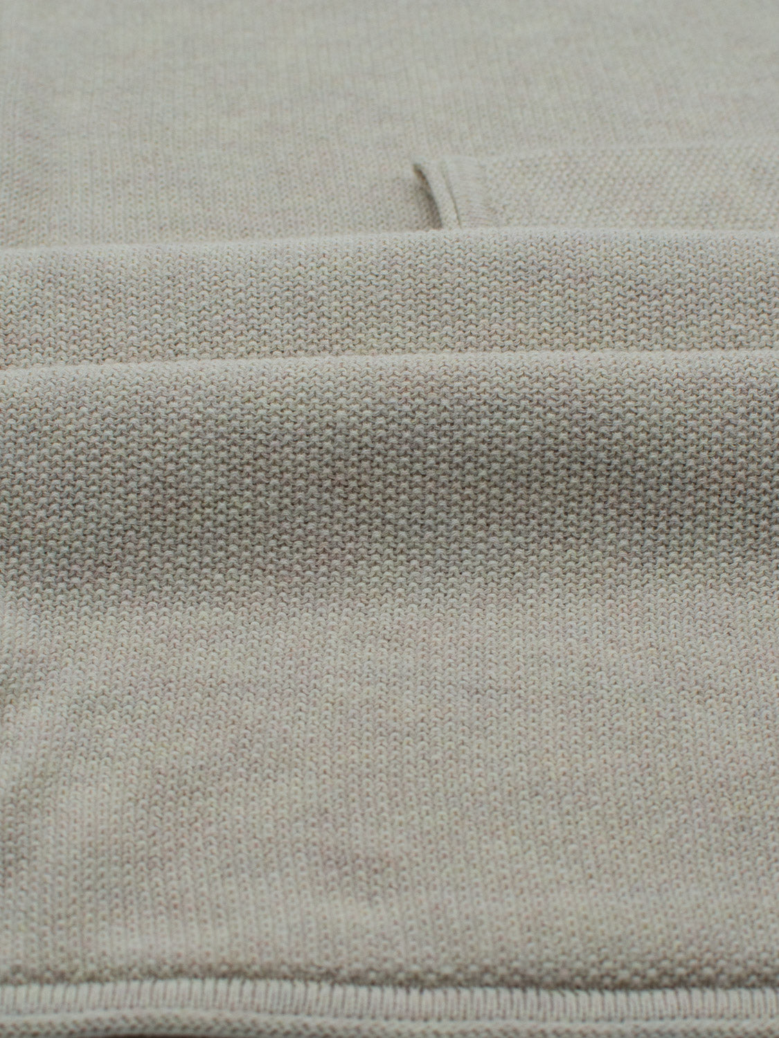 Close-up of the Madrid Rolled Neck Sweater Tee by ID Menswear in beige, featuring a mini popcorn knit texture with small, even stitches. The lightweight fabric is neatly folded, creating subtle shadows and depth.
