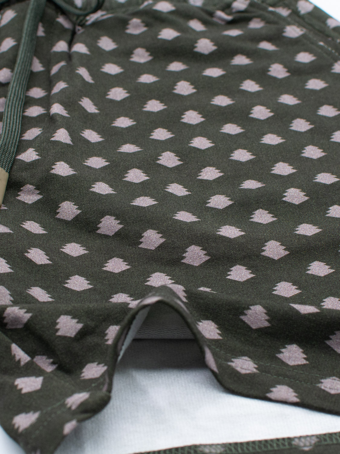 Close-up of a green fabric with beige diamonds, made from soft organic cotton. It appears to be part of the Samui Vintage Japanese Print Short by ID Menswear, featuring a drawstring on the left side.