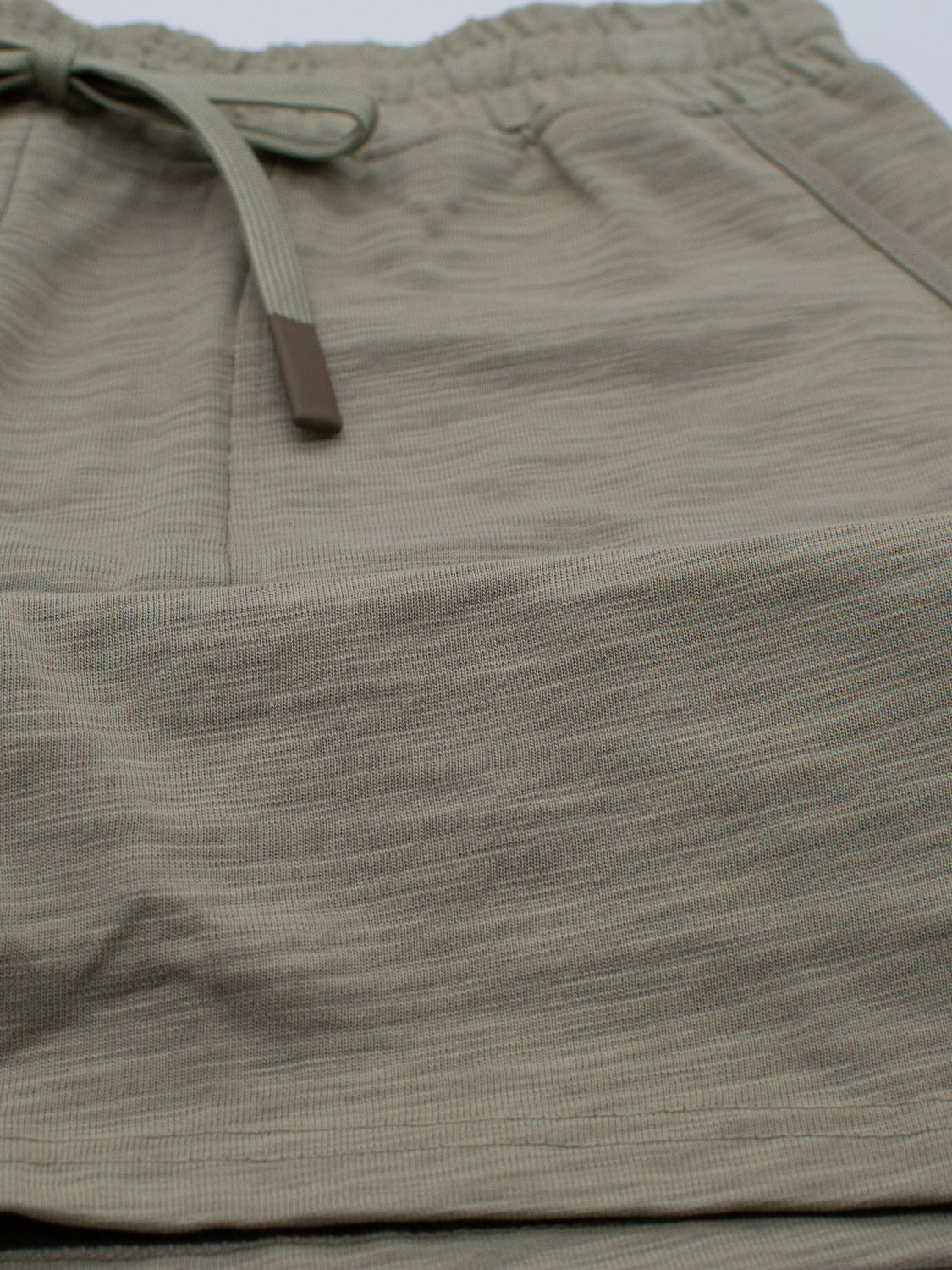 Close-up of the Kahala Slub Cotton Drawstring Short by ID Menswear in light olive green, featuring an elastic waistband and drawstring. The slub cotton gives a textured look for a relaxed and stylish fit.