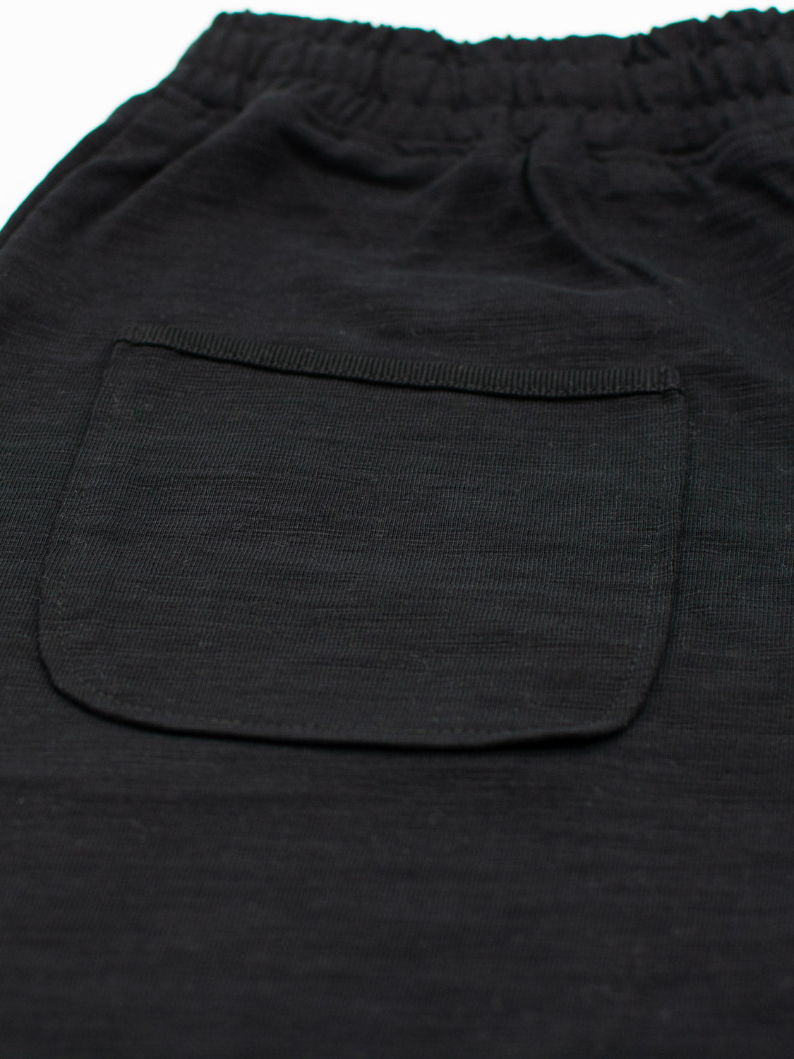 Close-up of ID Menswears Kahala Slub Cotton Drawstring Short in black, showcasing its textured cotton and relaxed fit. It features a single pocket with subtle stitching, an elastic waistband, and drawstrings, combining comfort and style.