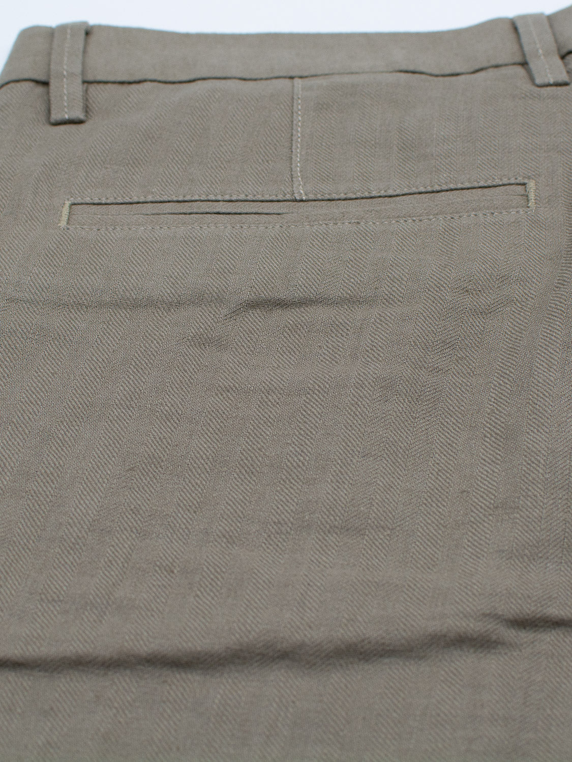 Close-up of the Kerala Linen Blend Chino Short by ID Menswear, showcasing the back pocket and waistband with belt loops. Made from a linen-cotton blend, it features a subtle herringbone pattern and visible stitching.