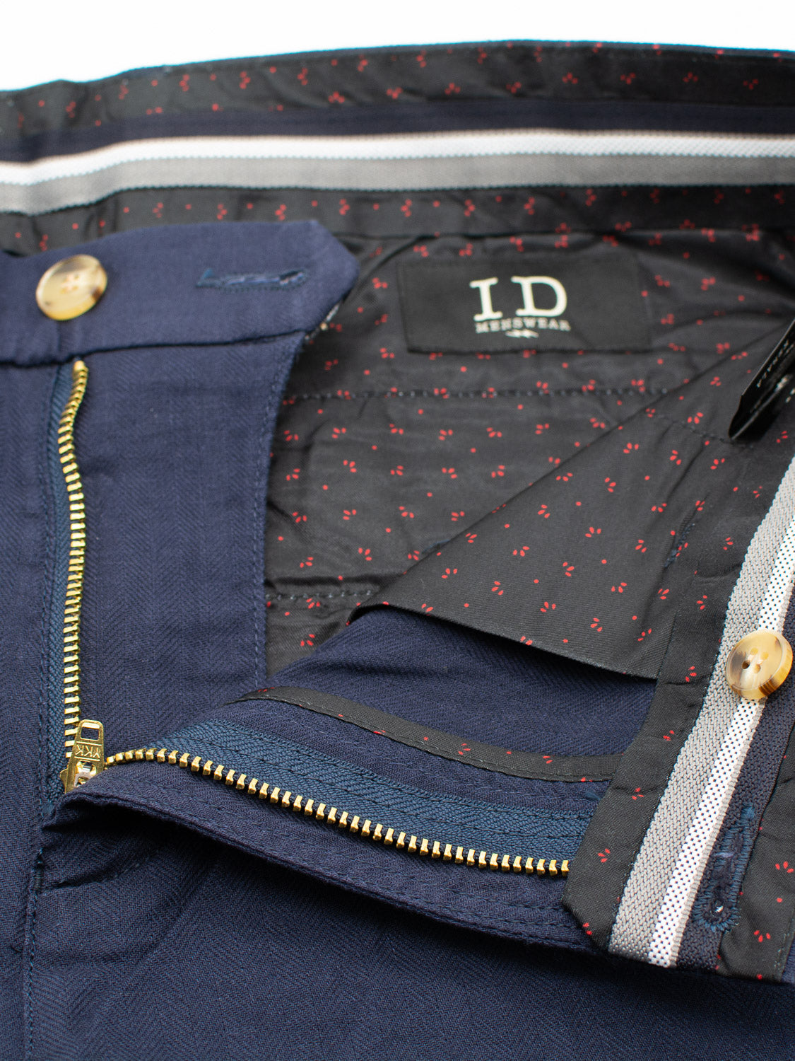 Close-up of the inside waistband of Kerala Linen Blend Chino Shorts in blue, featuring a linen-cotton blend. The shorts have a patterned lining with small red dots, zipper and button closure, striped inner waistband detailing, and a visible ID Menswear label.