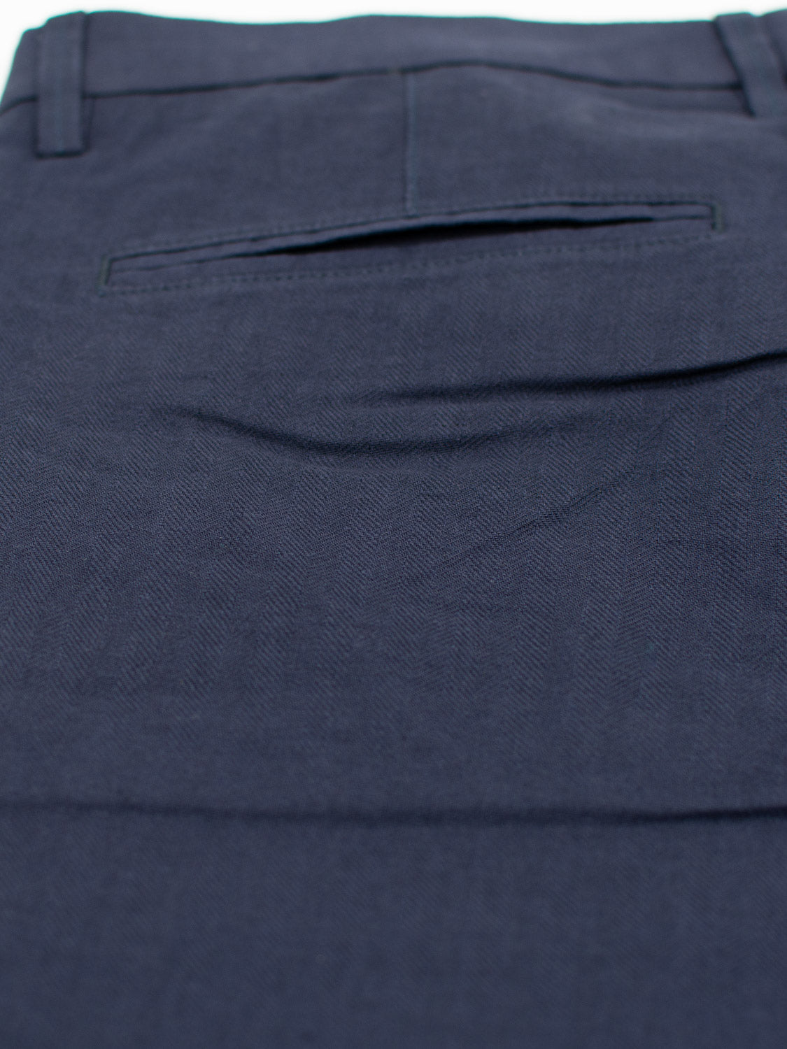 Close-up of the Kerala Linen Blend Chino Short by ID Menswear, featuring dark blue fabric with back pocket and seam details. The relaxed-fit linen-cotton blend boasts a subtle texture and neat tailoring.