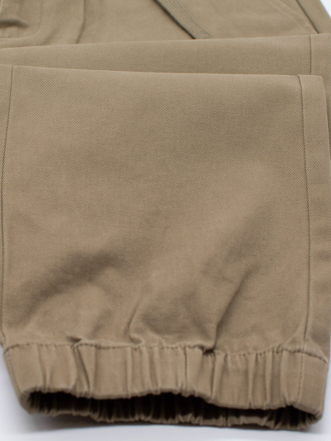 Close-up of ID Menswears Dyker Cotton Twill Drawstring Jogger in khaki, highlighting the cinched hem with elastic on the cotton twill fabric.