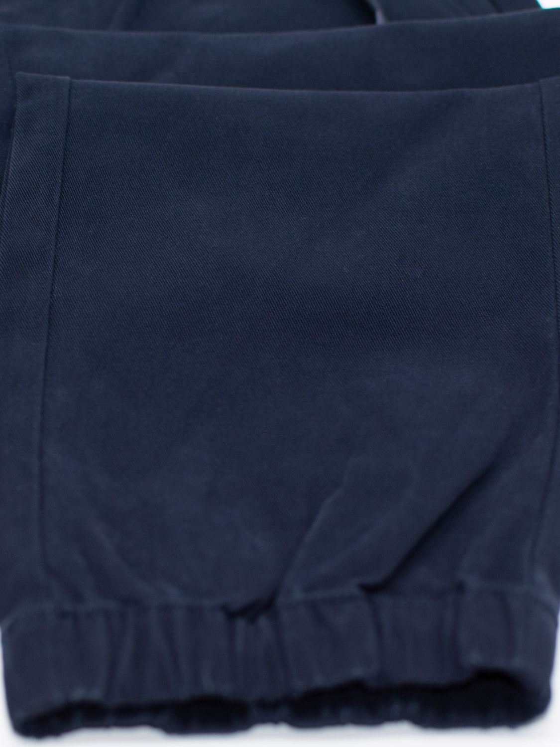 This close-up showcases the dark blue fabric of the Dyker Cotton Twill Drawstring Jogger by ID Menswear, featuring an elastic waistband. The soft material has a slight sheen, characteristic of these jogger pants.