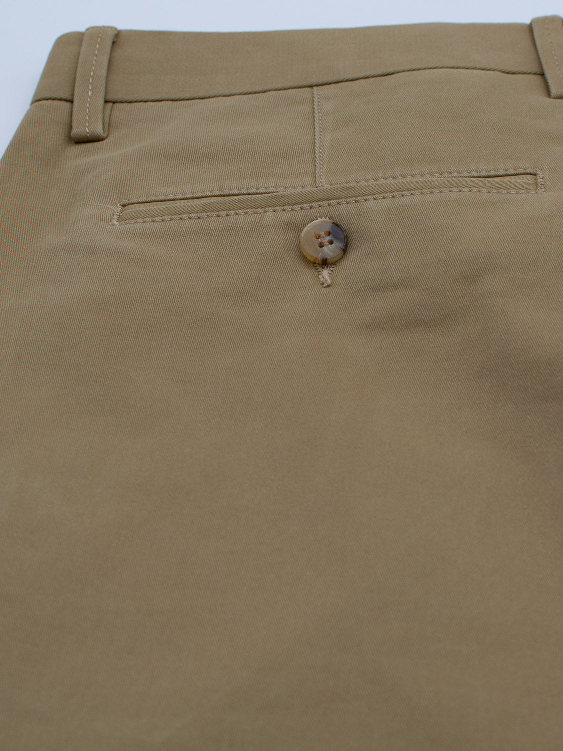 Close-up of the back pocket on beige ID Menswear Bushwick Twill Stretch Chino trousers, featuring a single button closure that complements the smooth fabric and subtle stitching.