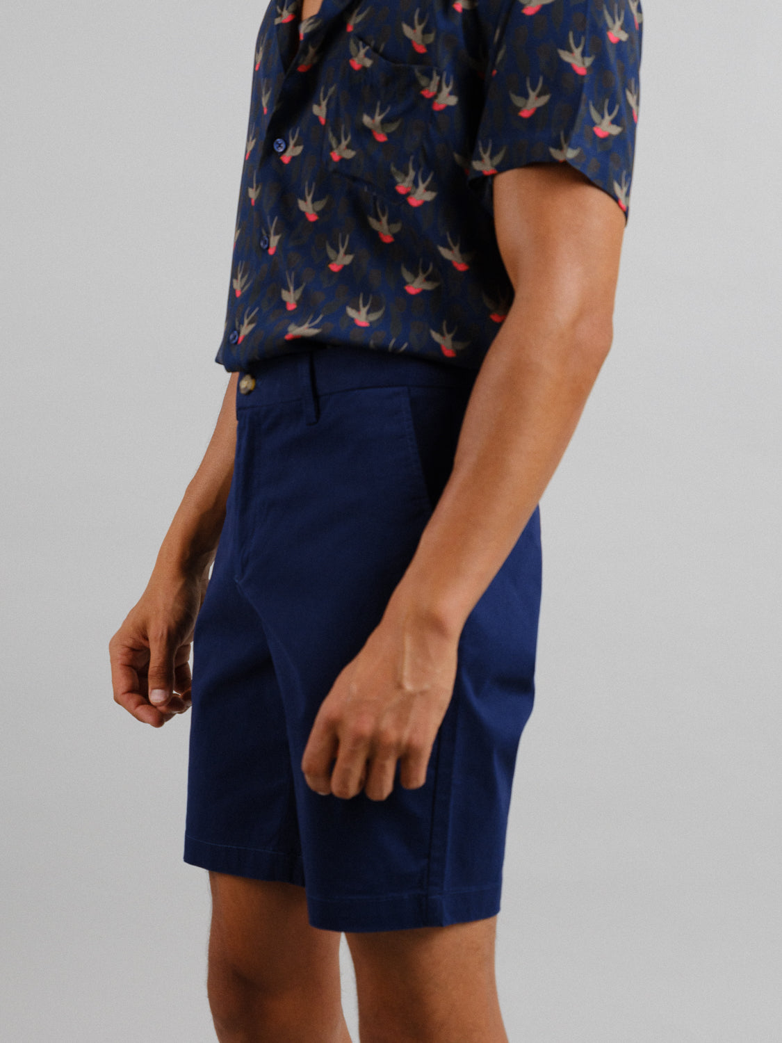 A person in a navy shirt with a bird pattern and At Ease Relaxed Chino Short by ID Menswear is pictured against a plain backdrop, showcasing the casual, versatile outfit.