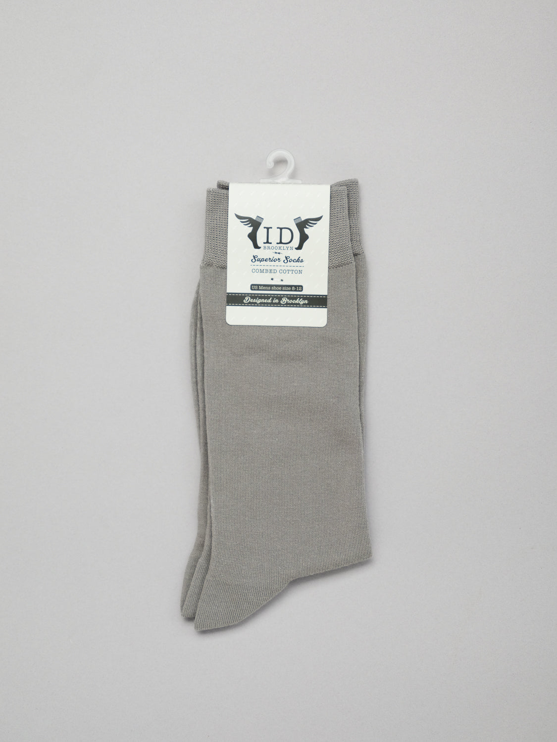 A pair of breathable, light gray ID Cotton Socks from ID Menswear is neatly folded with a white label at the top featuring the logo and Socks in stylized text. Ideal for all-day wear, the socks are displayed against a plain background with decorative elements.