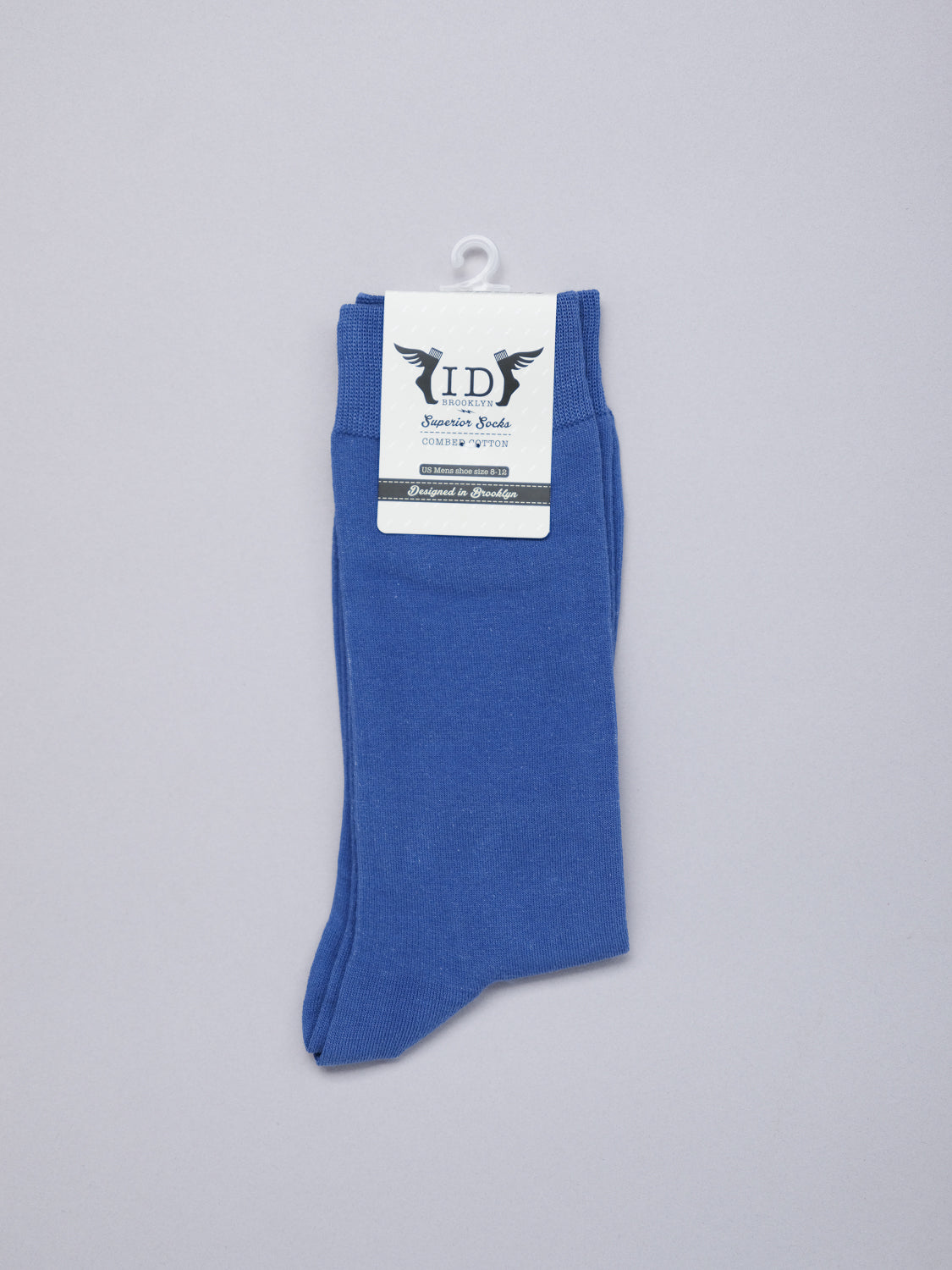 A pair of ID Cotton Socks by ID Menswear in blue with a top label featuring a winged logo and ID in bold. These breathable socks are ideal for all-day wear, neatly folded against a simple gray background.