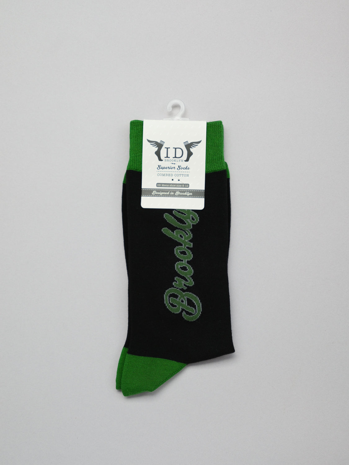 This premium black sock with green trim by ID Menswear features a white tag displaying brand details and the word Brooklyn in green script.