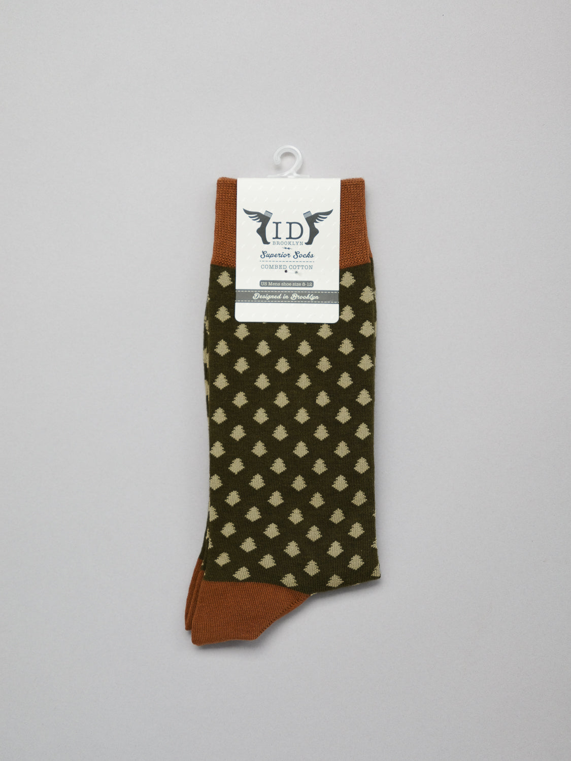 Ogawara Graphic Socks from ID Menswear showcase a light diamond pattern on dark green with brown accents, made from premium combed cotton. The socks offer breathability and stretch, highlighted by their branding against a plain gray backdrop.