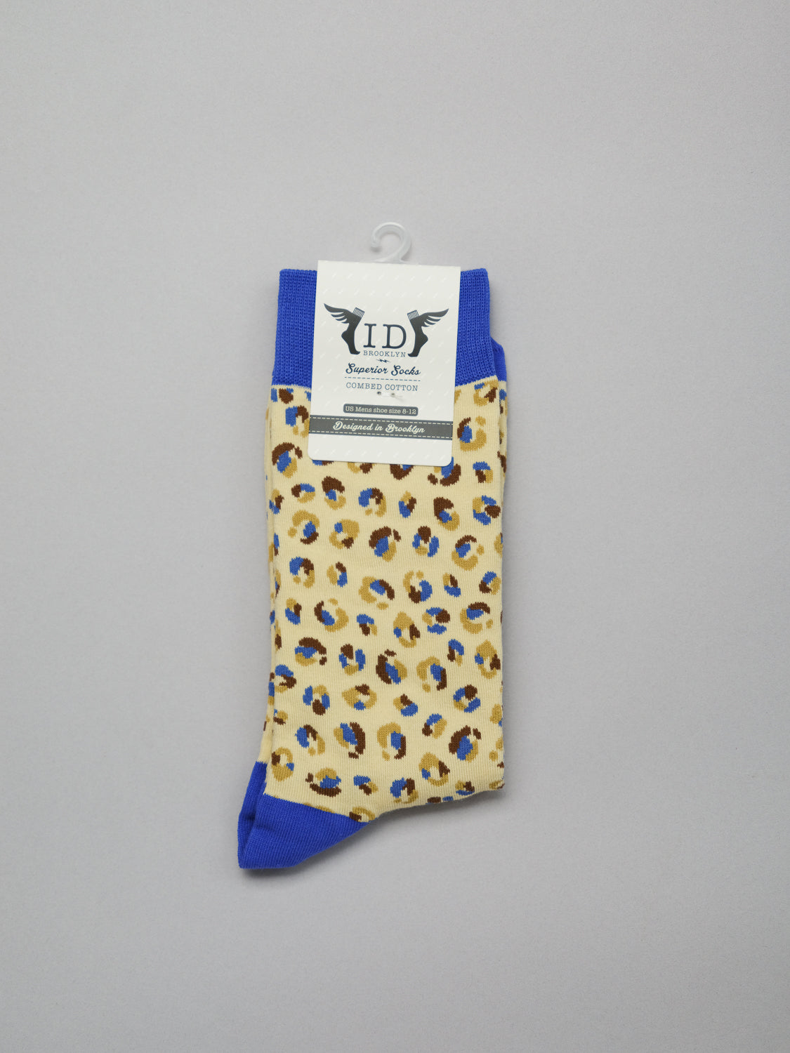 A pair of vibrant yellow, blue, and black Cheetah Graphic Socks from ID Menswear features blue toe caps and heels. Made from soft combed cotton, theyre equipped with a label and hanger for easy display.