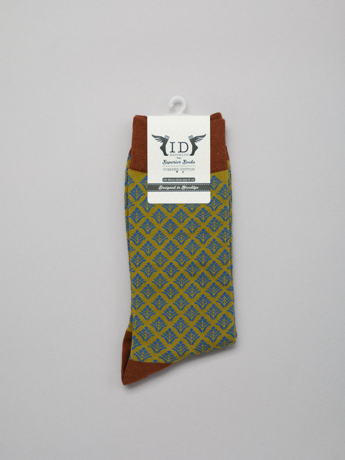 Retro Graphic Socks by ID Menswear, featuring a blue and brown design against a plain background, are made from premium combed cotton. They showcase IDs winged logo and additional small text on the label.