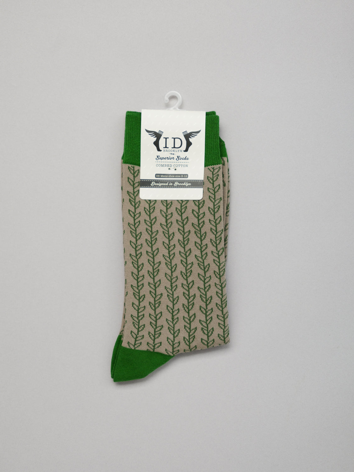 Introducing ID Menswears Kombu Graphic Socks: breathable combed cotton socks with a green leaf pattern on beige, featuring green cuffs, heels, and toes. Packaged elegantly with brand logo and text.