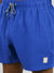 Close-up of a person wearing Oyogu Quick Dry 4 Way Stretch Swim Trunk by ID Menswear in bright blue, made from recycled plastic bottles, with a black and white drawstring and a small rectangular patch near the left hem.