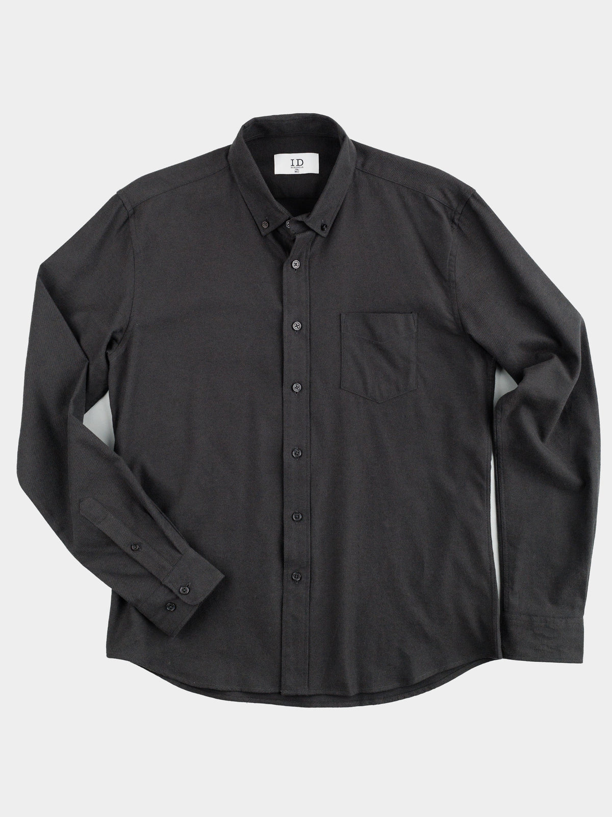 The Magnus Brushed Twill Solid Flannel Shirt by ID Menswear is a black long-sleeve button-up crafted from brushed twill with a classic collar and one chest pocket, featuring subtle texture. Displayed against a plain white background.