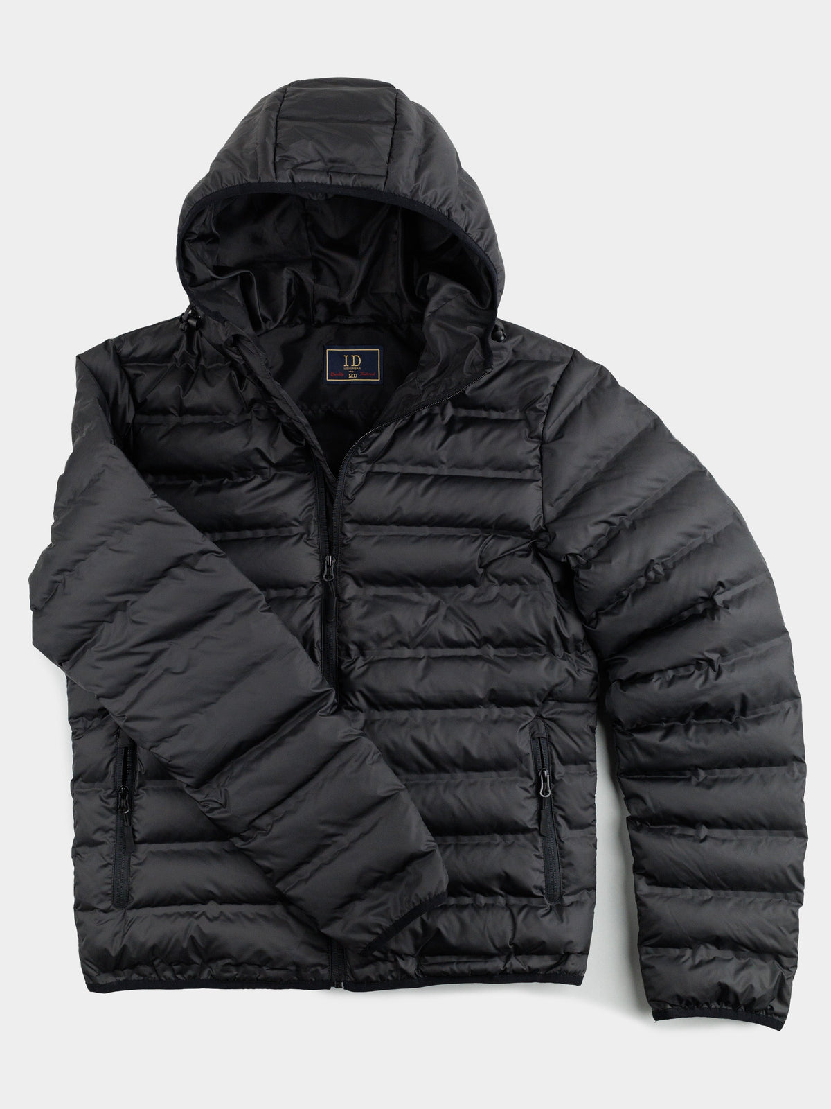 The ID Menswear Yukon Hooded Puffer Jacket, with a regular fit polyester shell, hood, front zipper, and two zippered side pockets, is laid flat on a white background with one sleeve folded across the body.