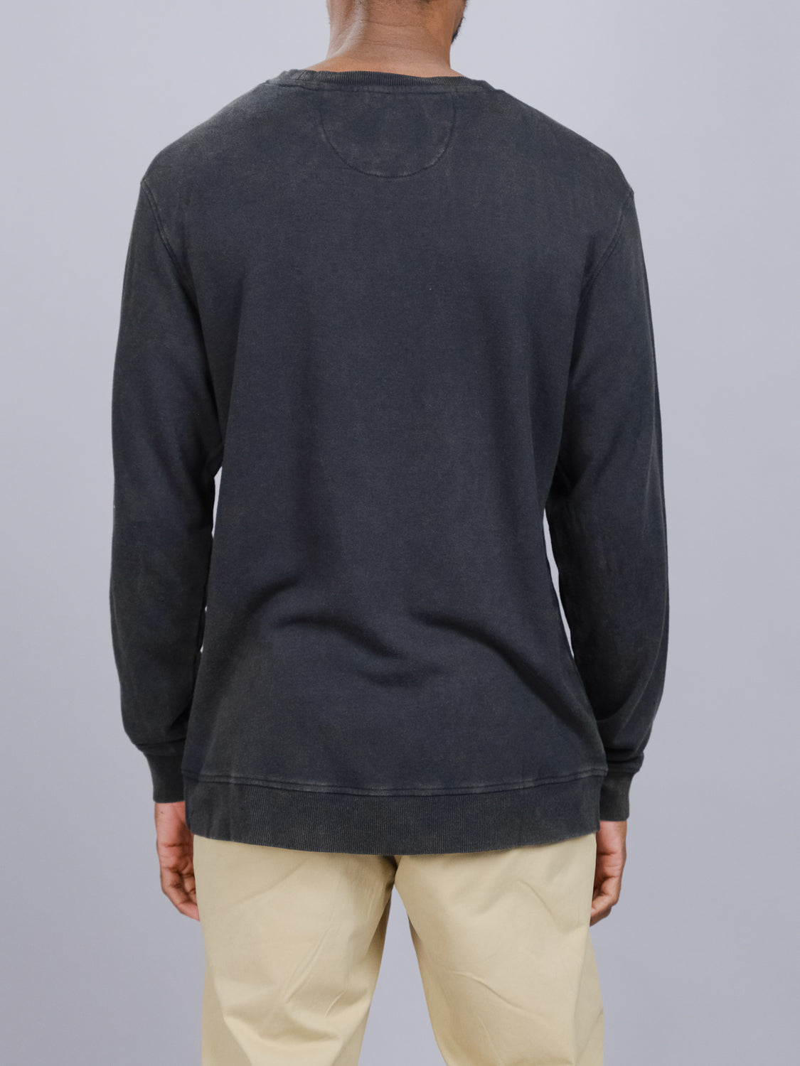 A person is shown from the back wearing a Champ Bamboo Organic Cotton Sweatshirt in black and beige pants. The ID Menswear shirt features a relaxed fit, vintage wash, and a visible top seam, set against a plain light gray background.