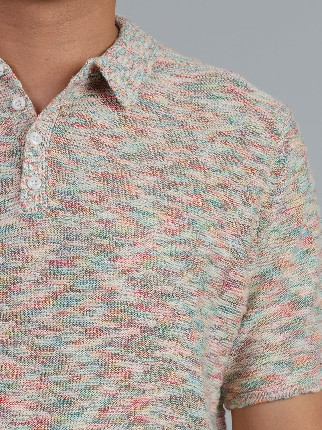 A person wears the Miami Reverse Knit Cotton Polo by ID Menswear, showcasing pastel pink, blue, green, and beige in a textured knit. The breathable cotton shirt with buttons is perfect for casual settings against a gray background.