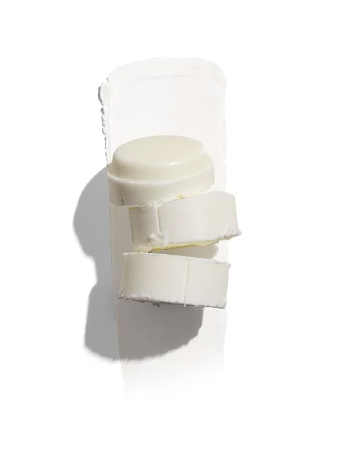 A white cylindrical Jack Black Black Reserve™ Pit Boss® Antiperspirant & Deodorant stick for men, shown on its side with the cap off and two thick slices cut, rests on a white background with minimal shadow.