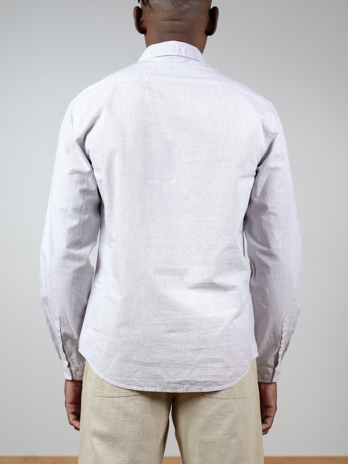 A person, seen from behind against a plain background, wears the Darwin Long Sleeve Shirt by ID Menswear with beige pants.