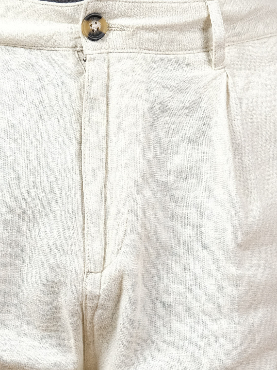 Close-up of the front of the !Solid Ethan Tapered Pleat Pant, featuring a high-waisted beige linen design with visible waistband, button, zipper, and subtle fabric creases.