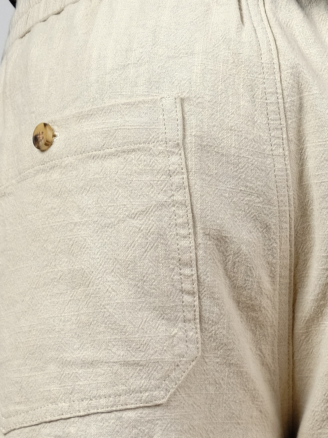 Close-up of the Sahara Linen Cotton Pant by ID Menswear, showing a beige linen-cotton blend pocket with stitched seam and button at the top left. The relaxed fit and detailed fabric texture are clearly visible.