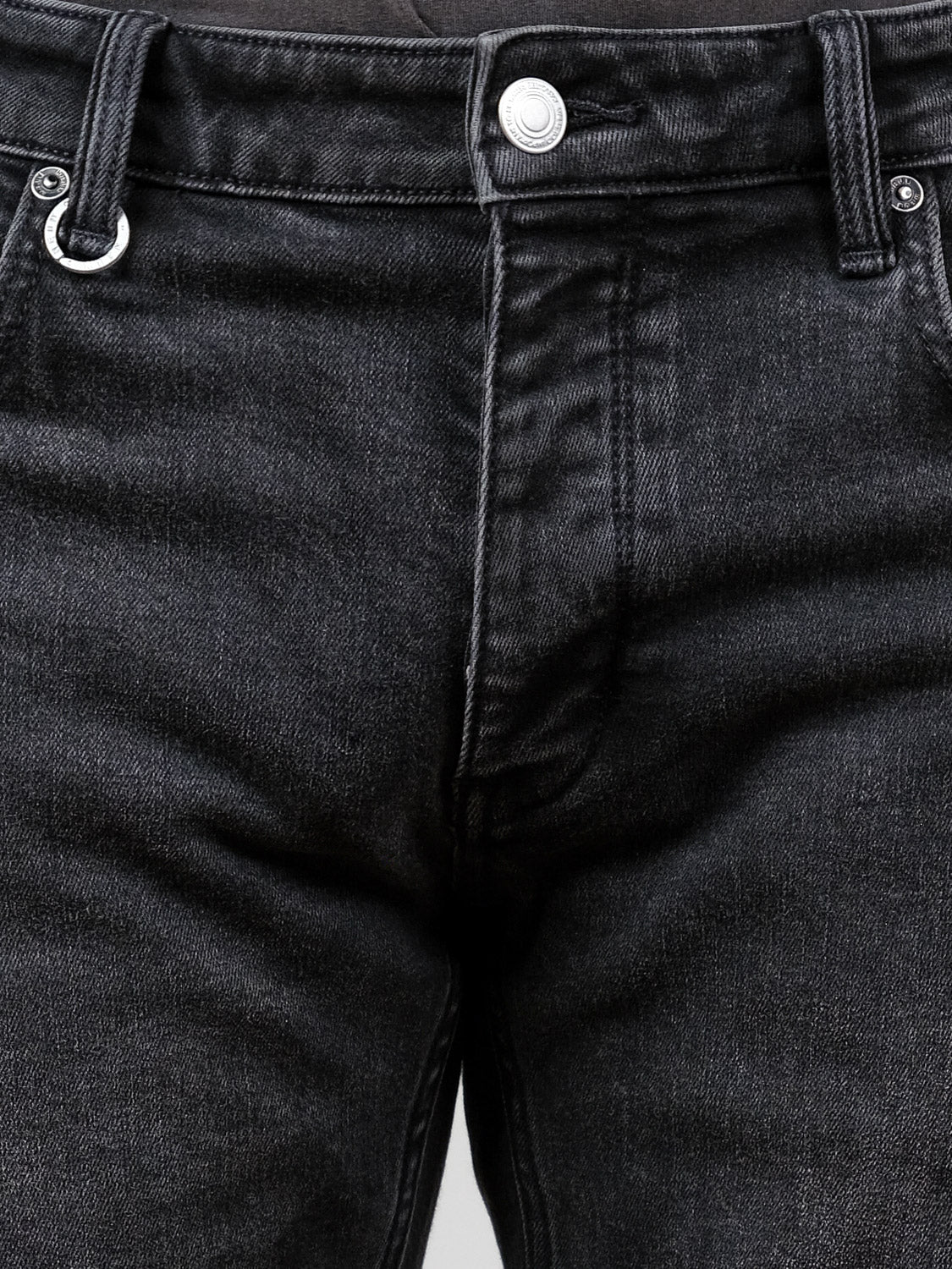 Close-up of the waist and upper legs of a person wearing Neuw Lou Straight Cashbah jeans by Neuw, featuring faded black denim, a silver button, and visible belt loops.