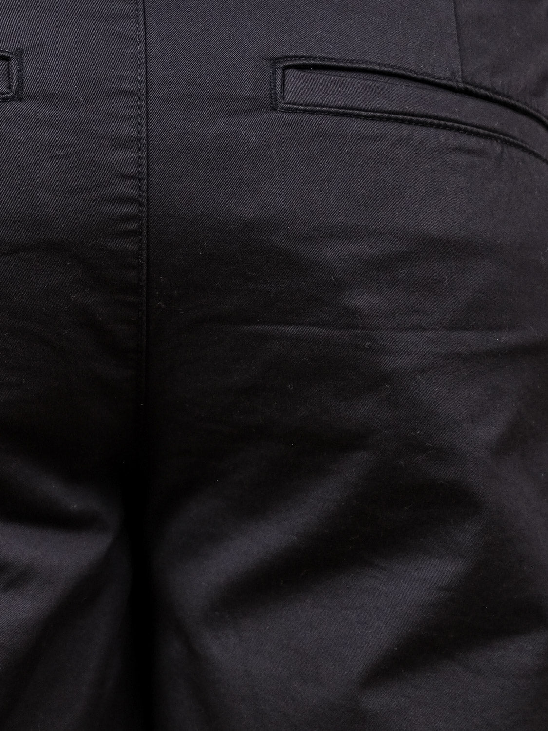 Close-up of the back of a pair of !Solid Bishop Shorts in black, highlighting fabric texture, stitching, and two back welt pockets—crafted with the same attention to detail as our regular fit shorts.