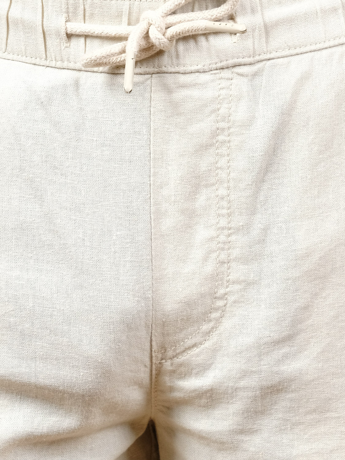 Close-up of the Aurelius Elas Short by !Solid—light beige linen shorts with an elastic waistband, front drawstring, and breathable, soft-textured fabric for comfortable, effortless style on warm days.