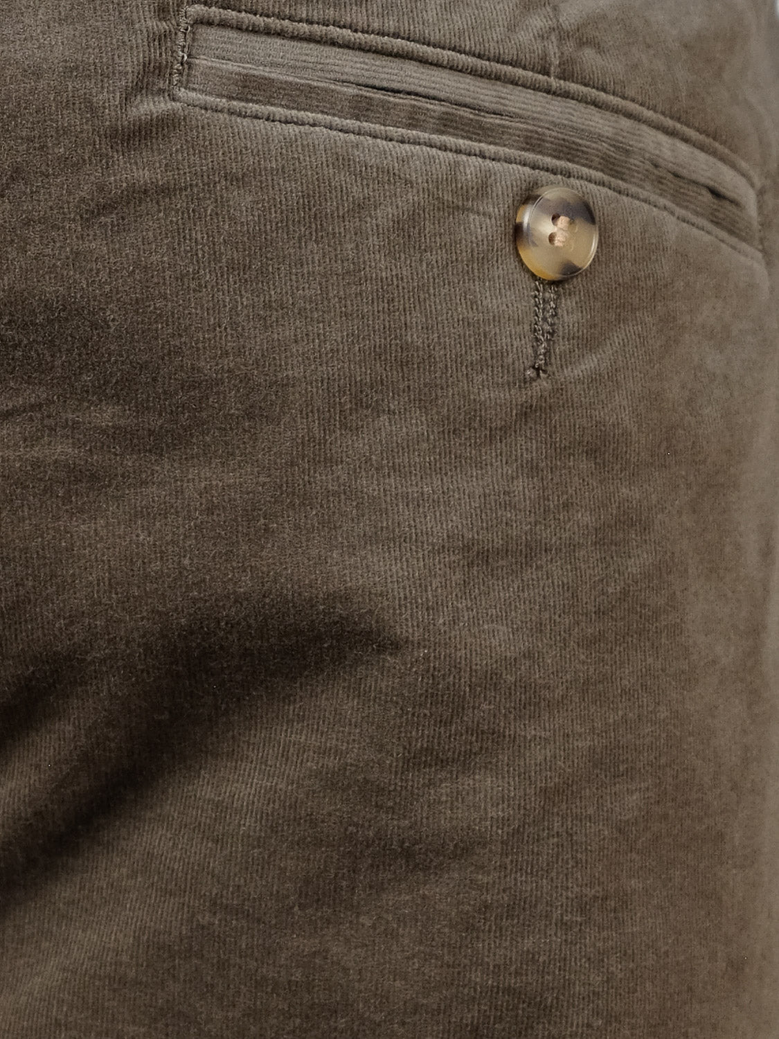 Close-up of the Odyssey Corduroy Stretch Short by ID Menswear, showing its brown corduroy texture, back pocket with single button closure, visible stitching details, relaxed fit, and elastic waistband for comfort.