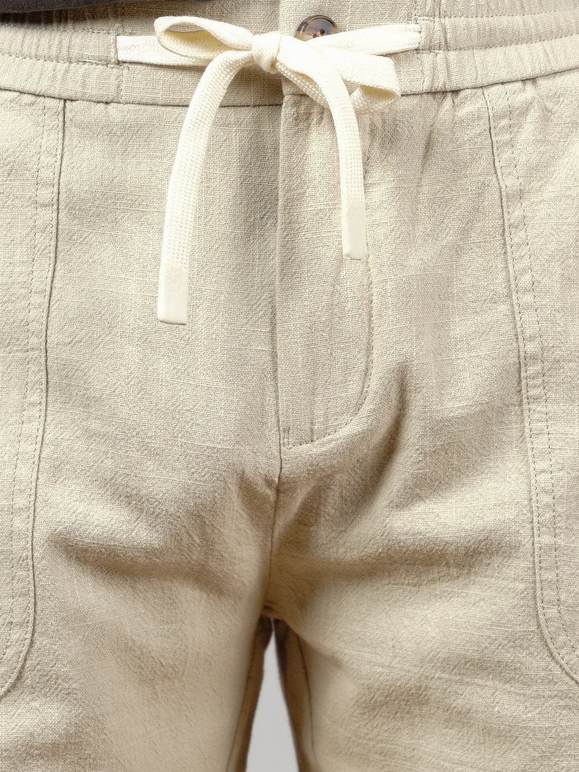 Close-up of the Phi Phi Linen Blend Drawstring Short by ID Menswear, featuring a light beige color, elastic waistband, drawstring tie, and visible seams—ideal men’s casual shorts for relaxed summer days.