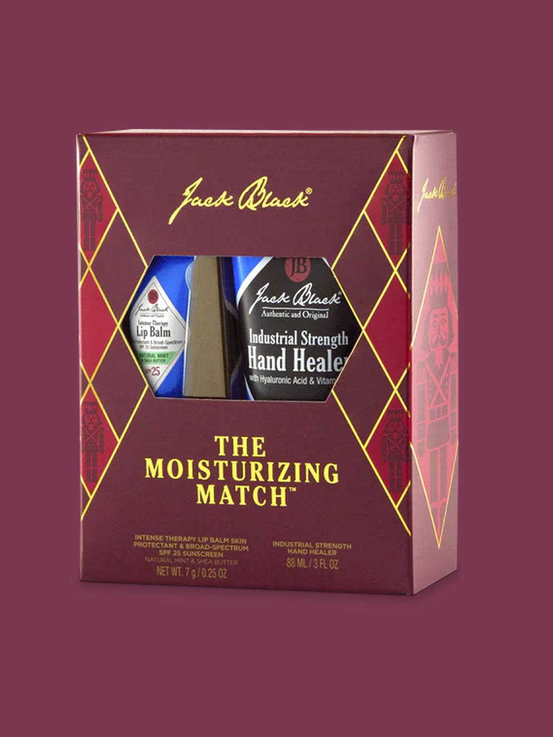 A maroon gift box labeled Jack Black The Moisturizing Match™ showcases Intense Therapy Lip Balm and Industrial Strength Hand Healer, both visible through a clear window and known for strong moisturizing power.
