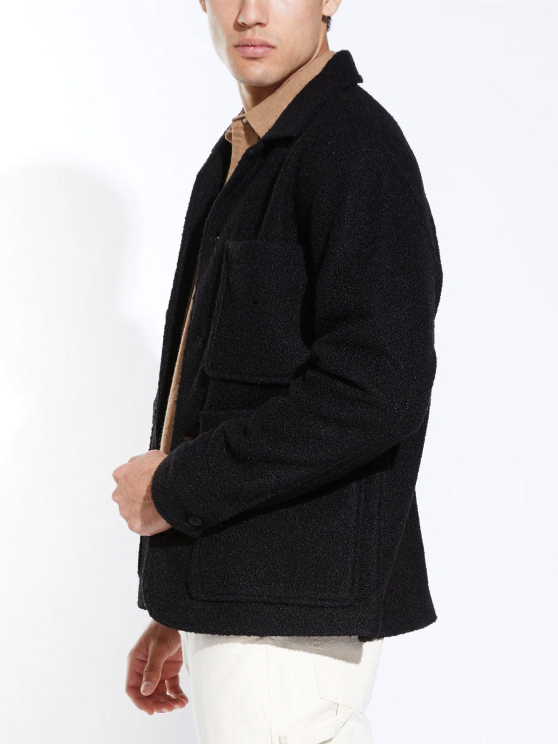 Someone models the Civil Society Abbott Relaxed Fit Walking Coat over a brown shirt and light-colored pants, standing sideways with their face partially out of frame against a plain white background.